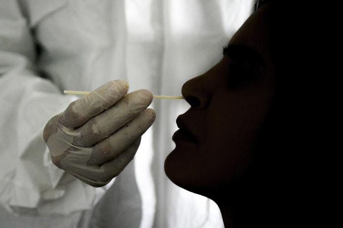Un doctor toma una muestra vía nasal para realizar una prueba de COVID-19.