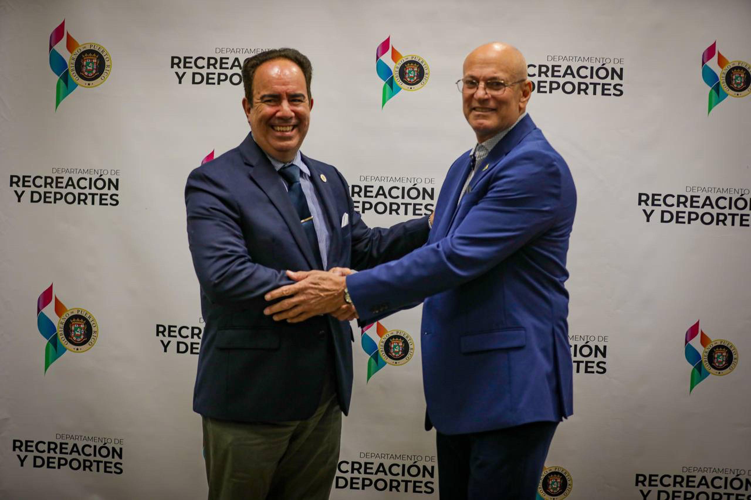 El presidente de la UPR, Luis Ferrao, estrecha manos con el secretario del DRD, Ray Quiñones.