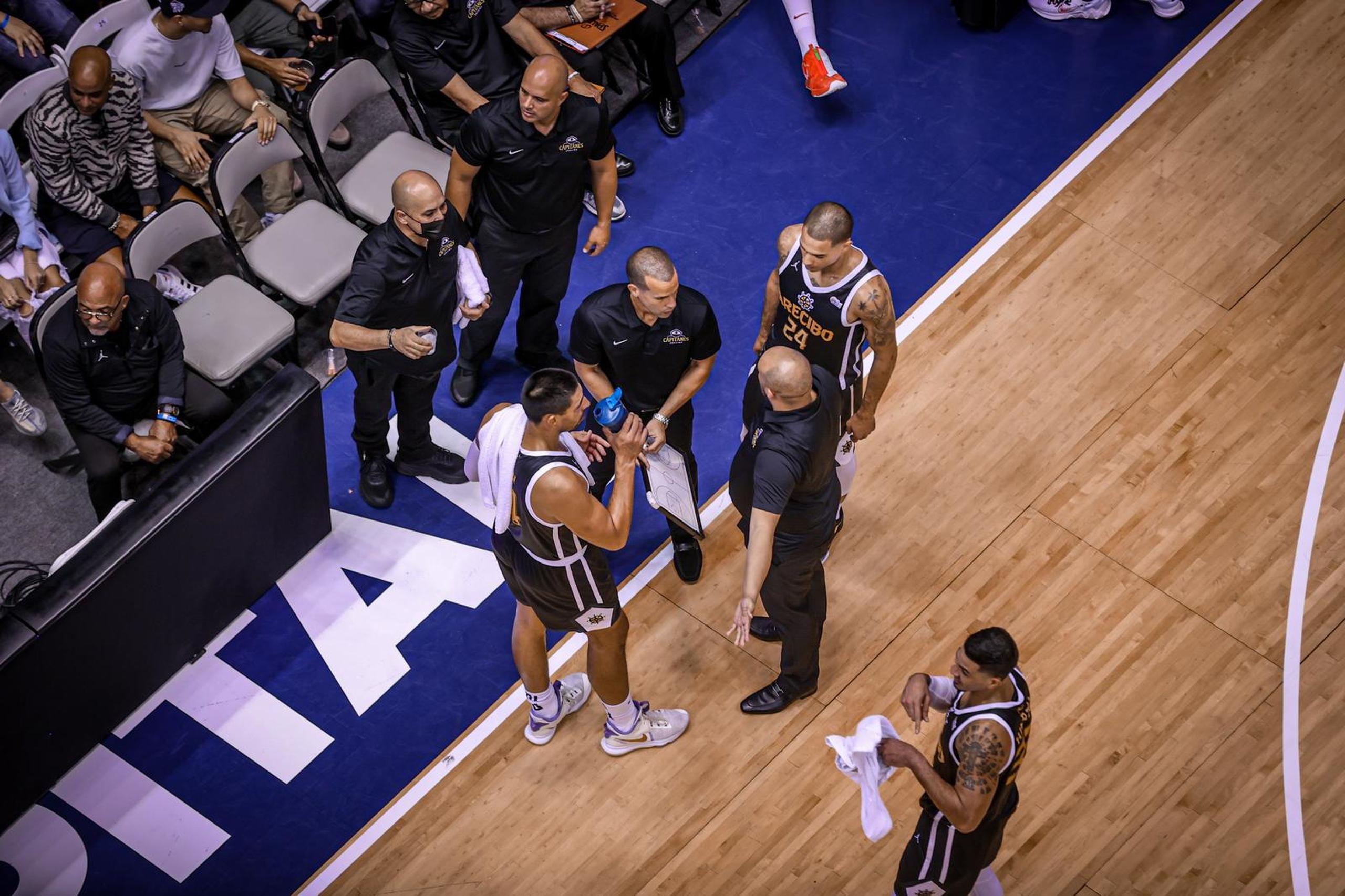 Pachy Cruz conversa, tableta en mano, con su centro Gustavo Ayón y no de sus asistentes durante el juego del miércoles en el que Arecibo ponchó su pase a la semifinal. 