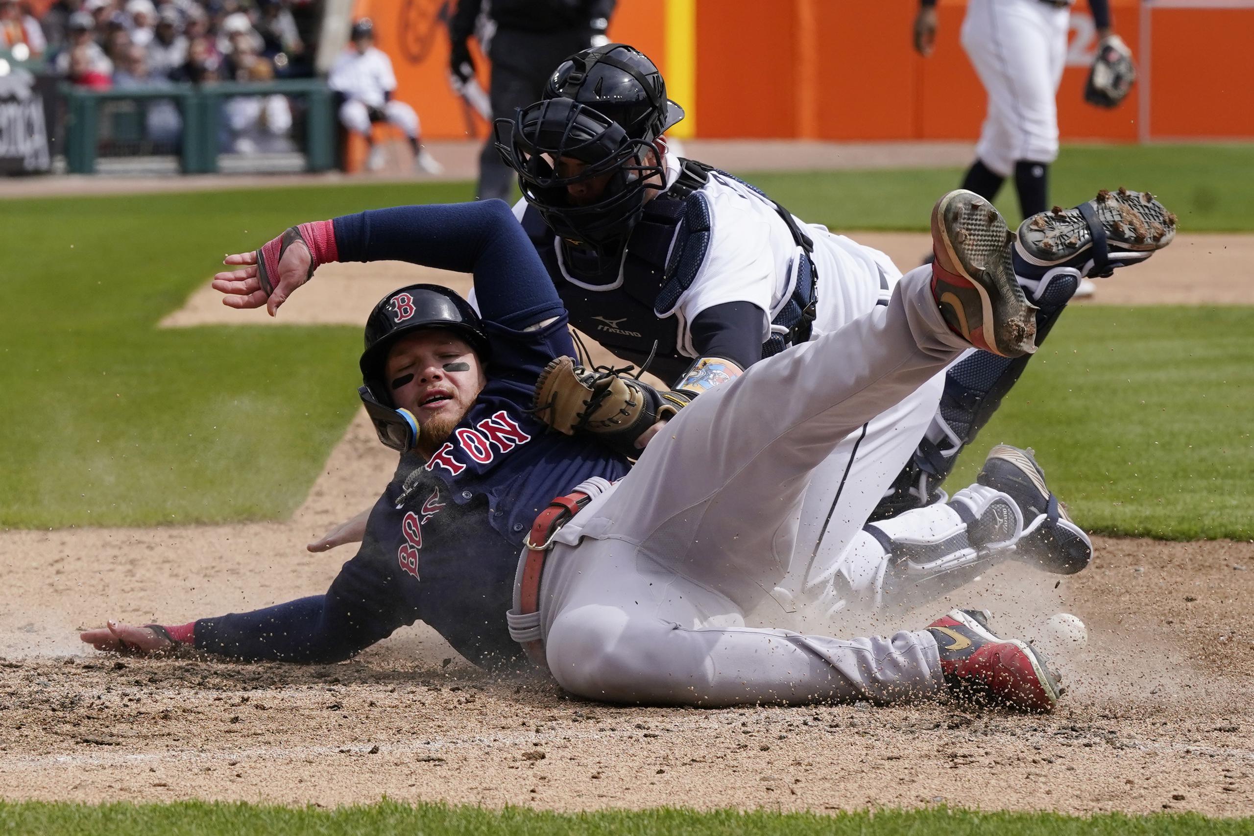 El receptor de los Tigers de Detroit, Jake Rogers, pierde el control de la pelota al intentar poner fuera en el plato al corredor de los Red Sox de Boston, Álex Verdugo.