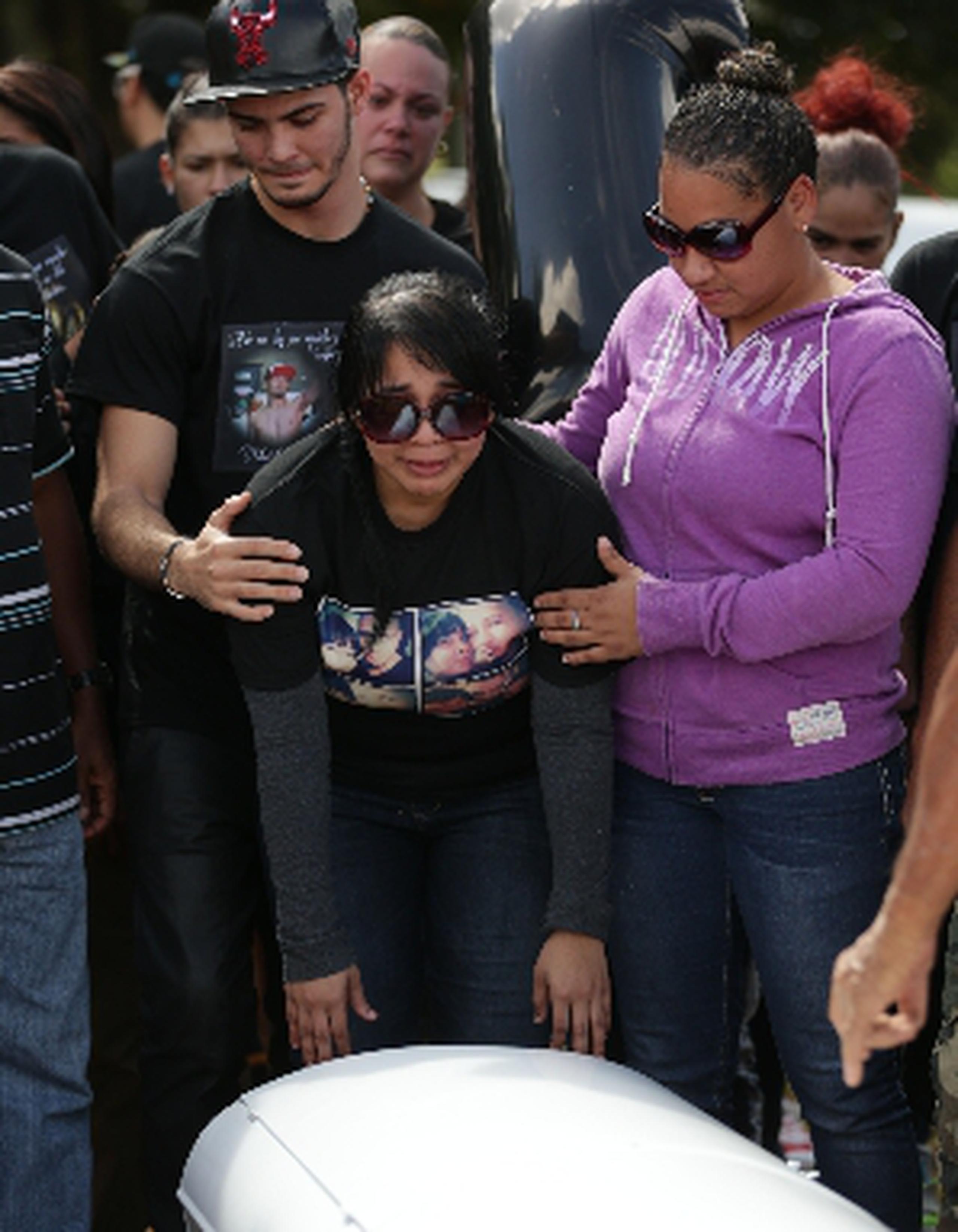 La viuda Lidianette Carmona recibe el consuelo de amigos y familiares en el momento en que el cuerpo de Christopher Rivera fue sepultado en Río Piedras. (teresa.canino@gfrmedia.com)