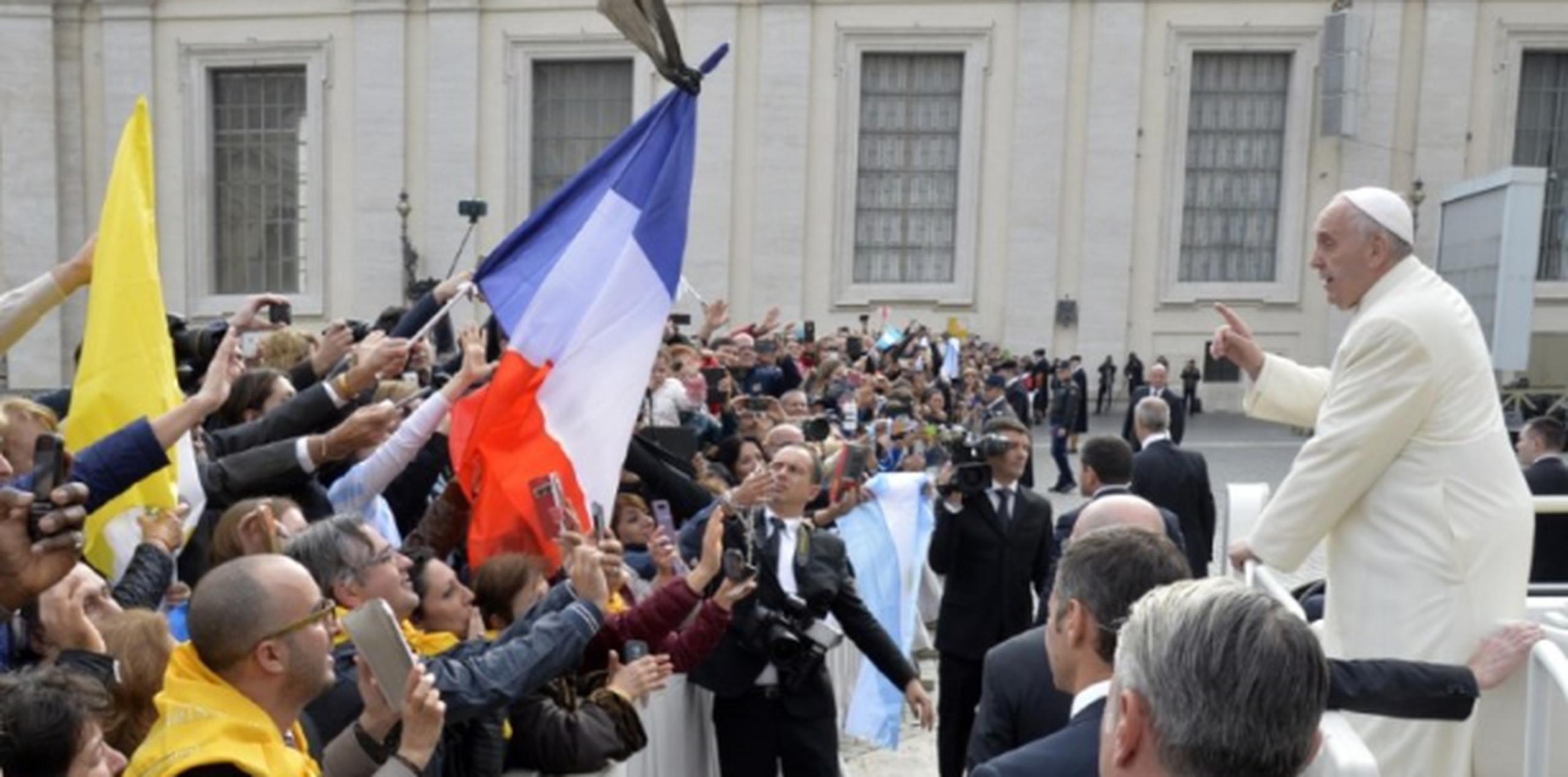 Una bandera de Francia es levantada por un asistente al sermón de ayer del Papa en Plaza San Pedro, Vaticano. (AFP)