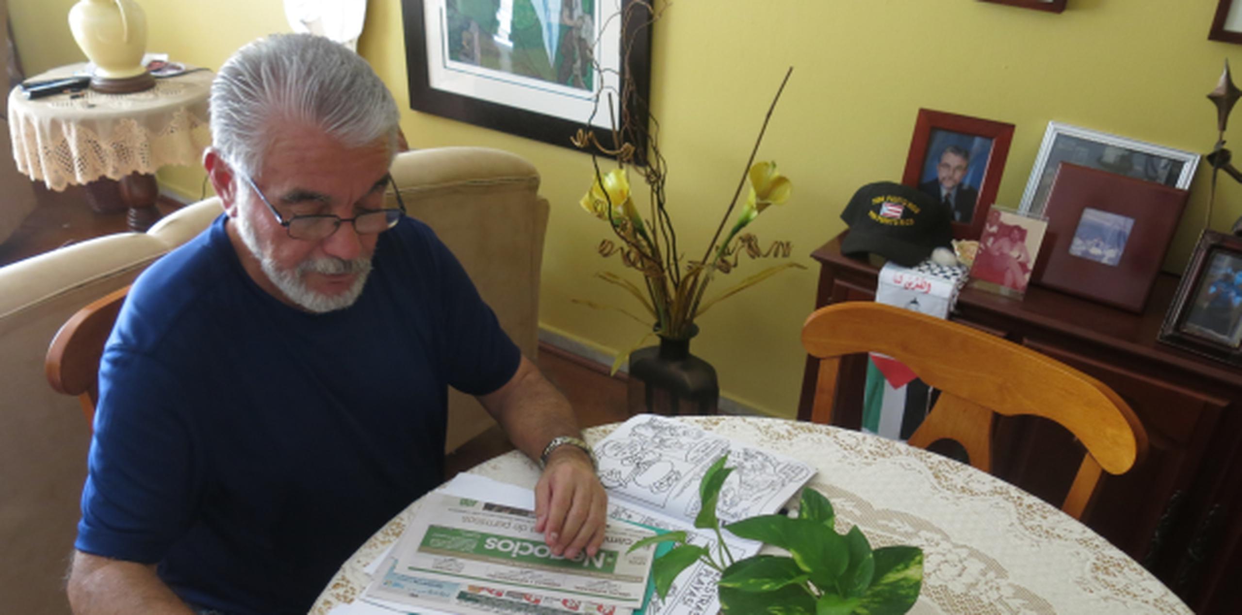 Juan Camacho revisa papeles como parte de su trabajo como ayudante de maestro de segundo grado en San Juan. (AP / Danica Coto)