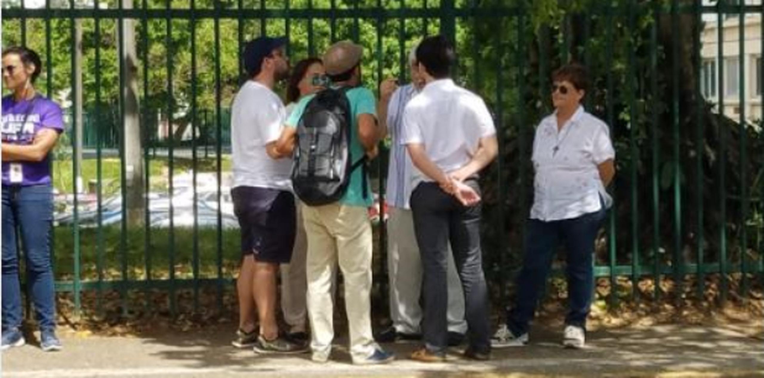 Profesores y estudiantes vestidos de blanco conversan ferente a los portones con uno de los estudiantes miembros del Comité Negociador. (Twitter/@MColonCruz)