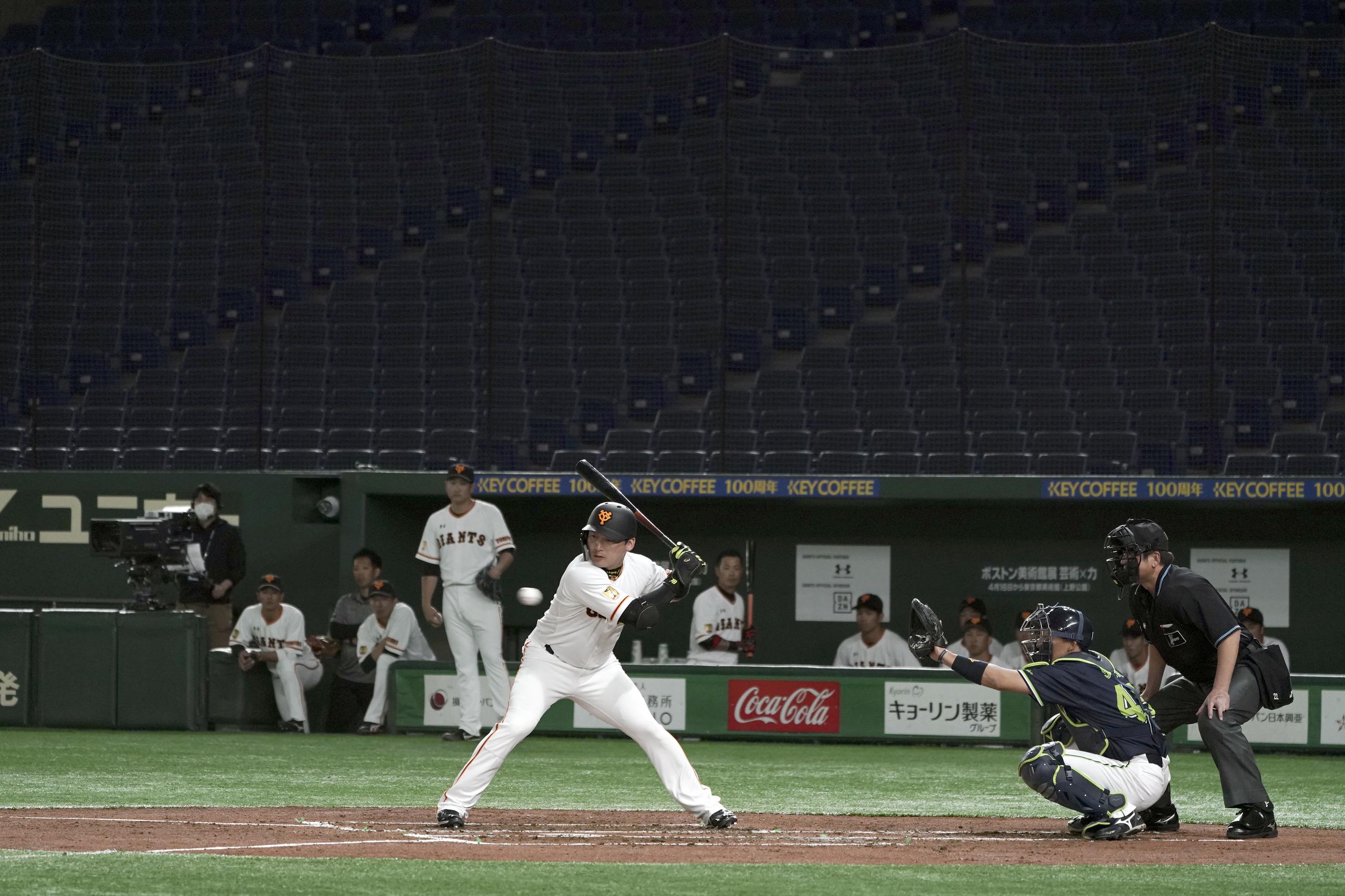 Esta imagen presenta un partido de pretemporada de los Yomiuri Giants ante los Yakult Swallows jugado sin público en el Tokyo Dome.