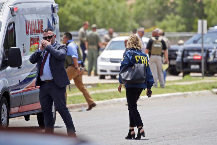 Las autoridades, incluyendo el FBI, se reúnen cerca de la Escuela Primaria Robb luego de la masacre el 24 de mayo de 2022, en Uvalde, Texas.