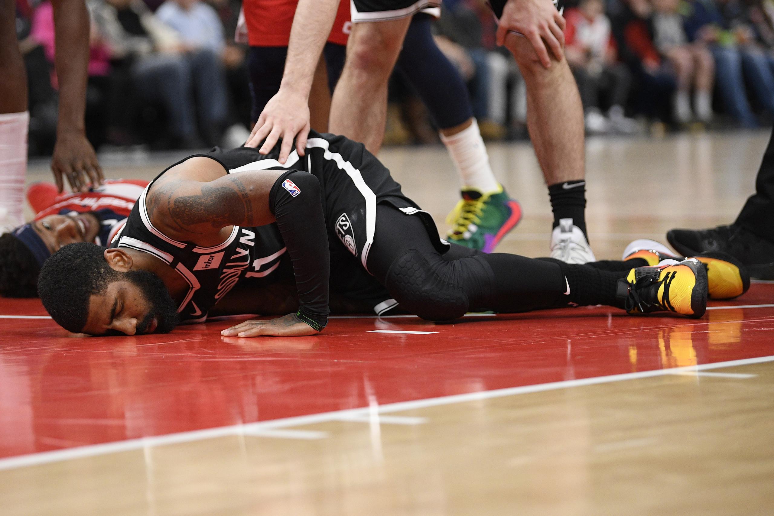En foto de un juego el 1 de febrero pasado, el base de los Nets Kyrie Irving queda tendido en la cancha tras lesionarse en el juego ante los Wizards de Washington.