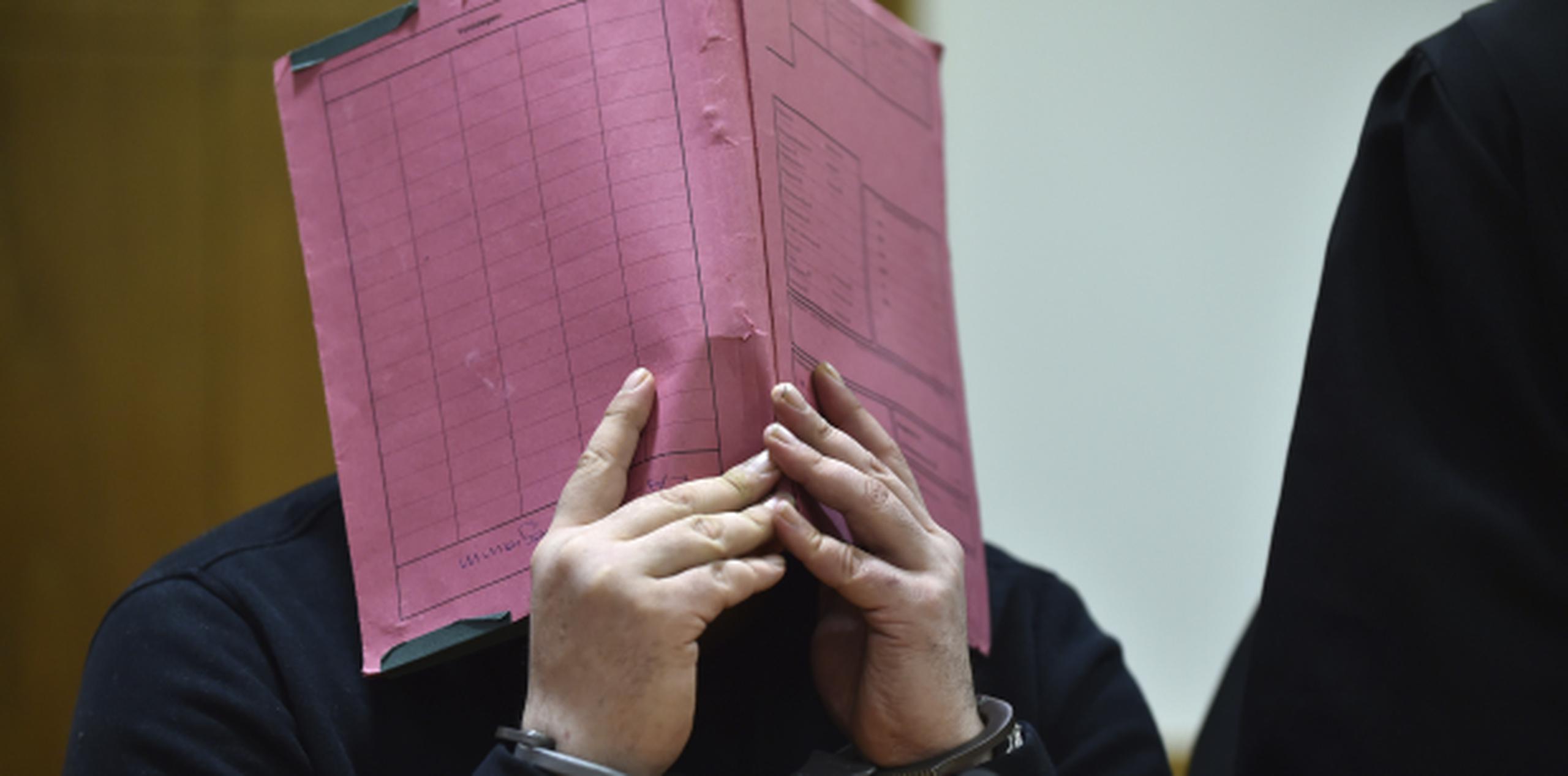 En esta imagen del 22 de enero de 2015, el enfermero Niels Hoegel se cubre el rostro durante su juicio en el tribunal regional de Oldenburg, en el norte de Alemania. (Carmen Jaspersen / dpa vía AP)