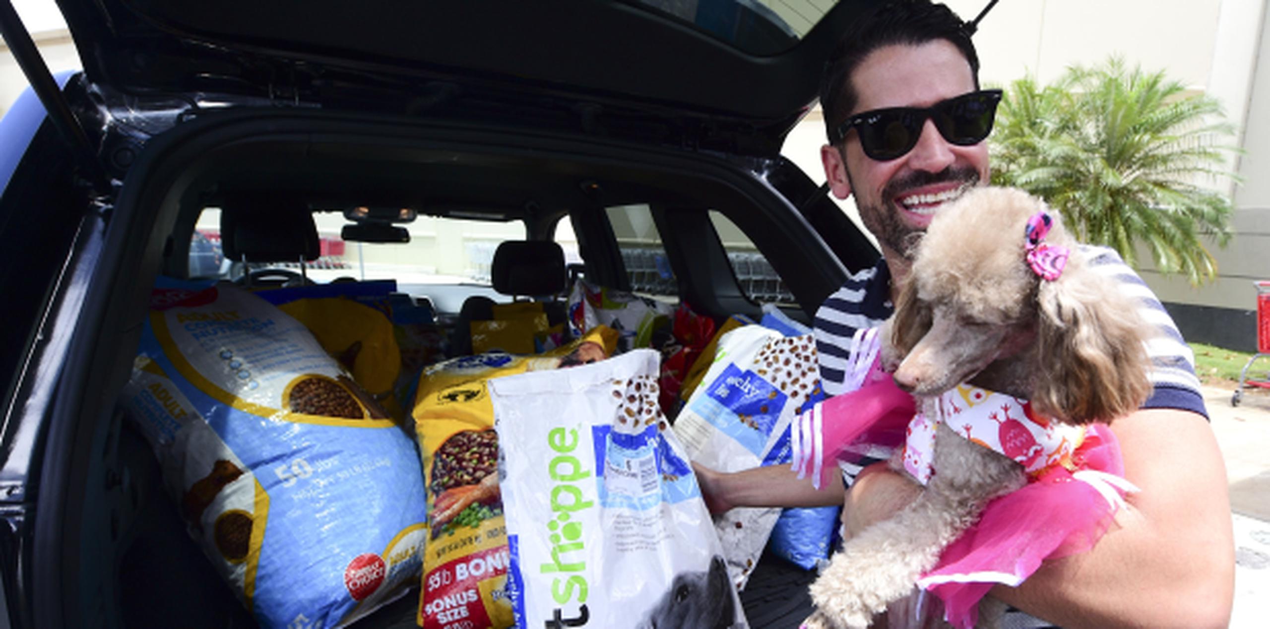 El estilista Johnny Ortiz acudió con su poodle Violeta para donar mil libras de comida. (tony.zayas@gfrmedia.com)
