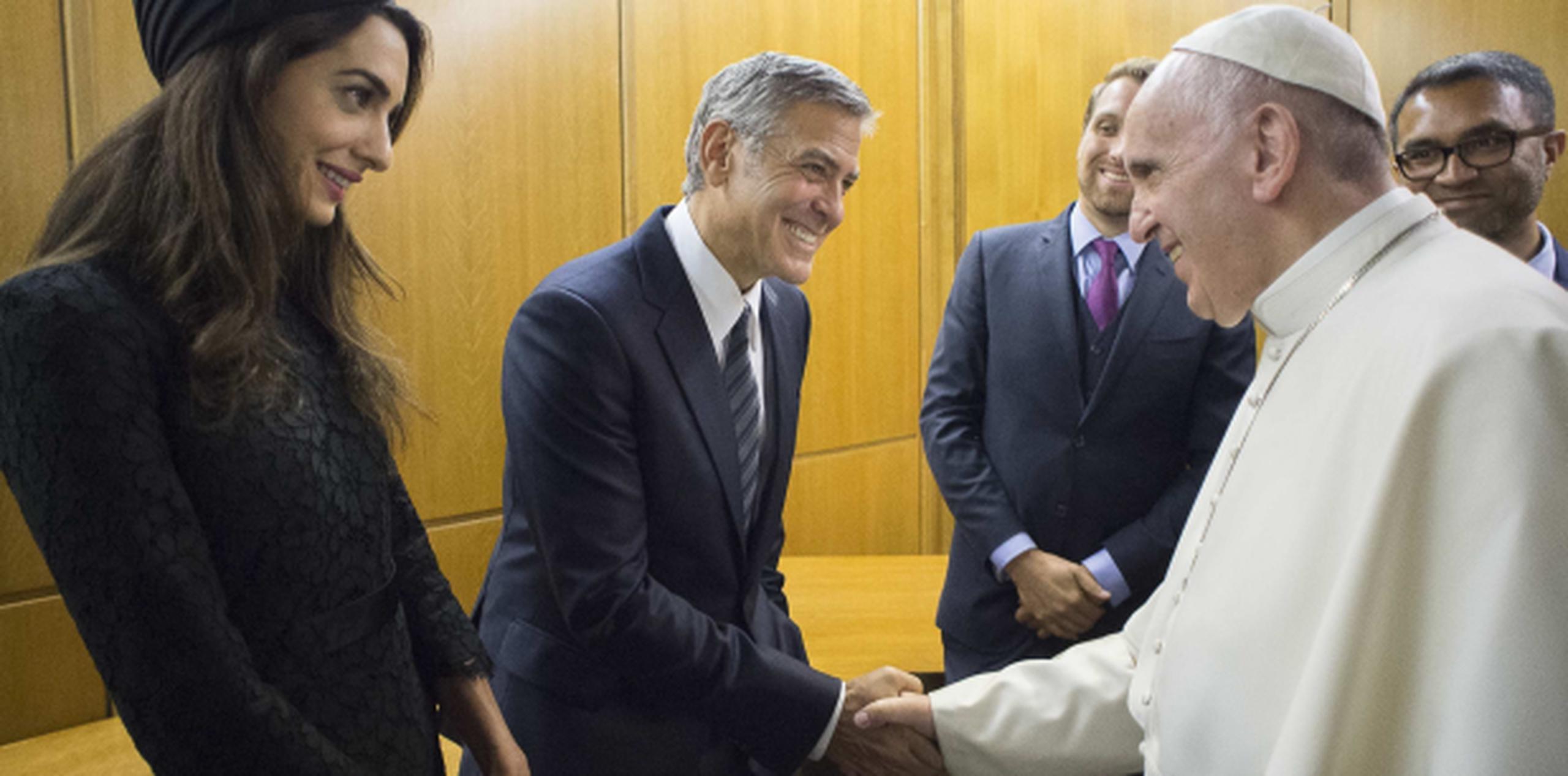 Sonrientes, George Clooney y su esposa Amal saludan al papa. (AP)