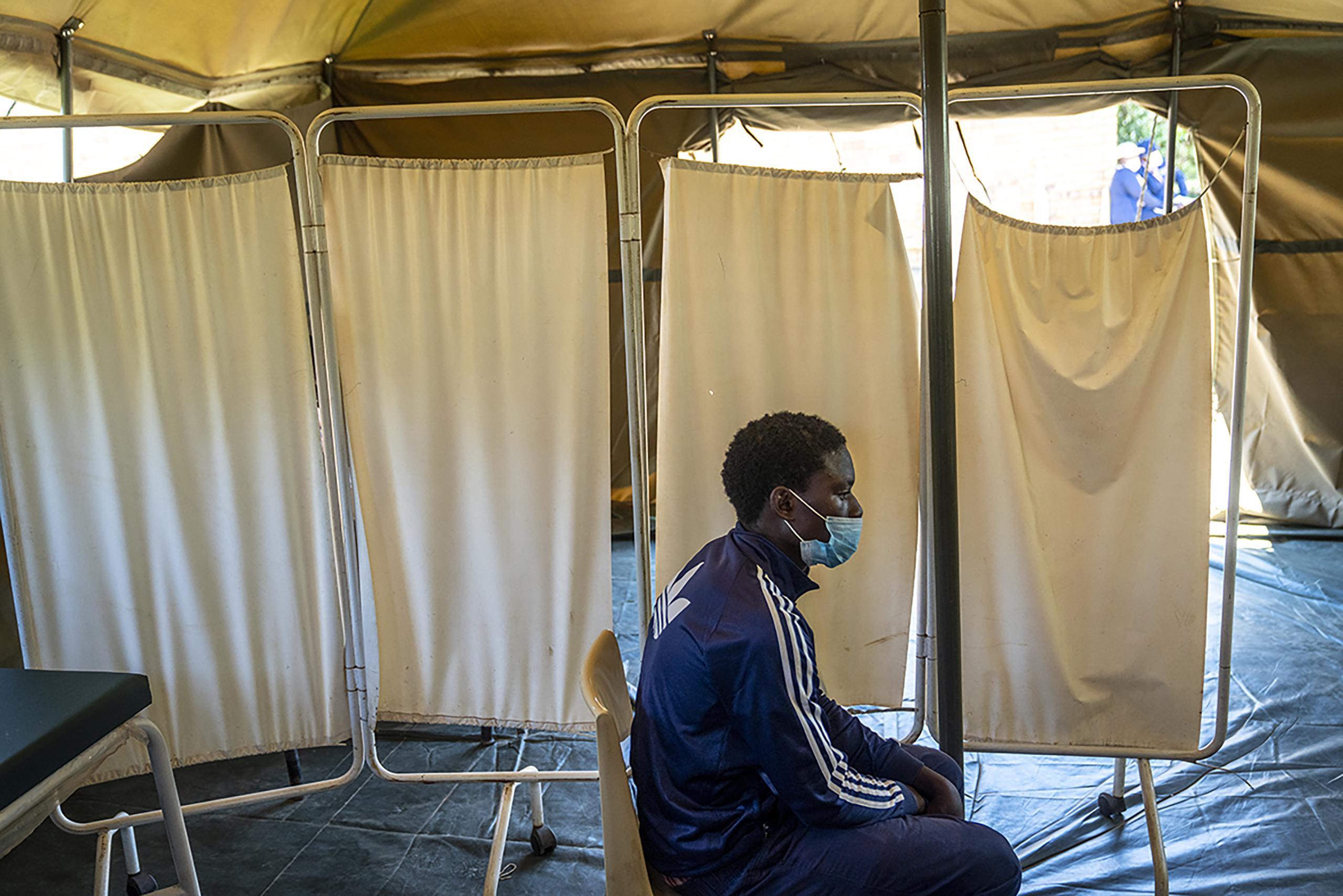 Esta fotografía muestra a un hombre que fue colocado en aislamiento luego de llegar a una clínica para recibir una vacunación en Lawley, cercano a Johannesburgo, Sudáfrica, el miércoles 1 de diciembre de 2021. (AP Foto/ Shiraaz Mohamed)