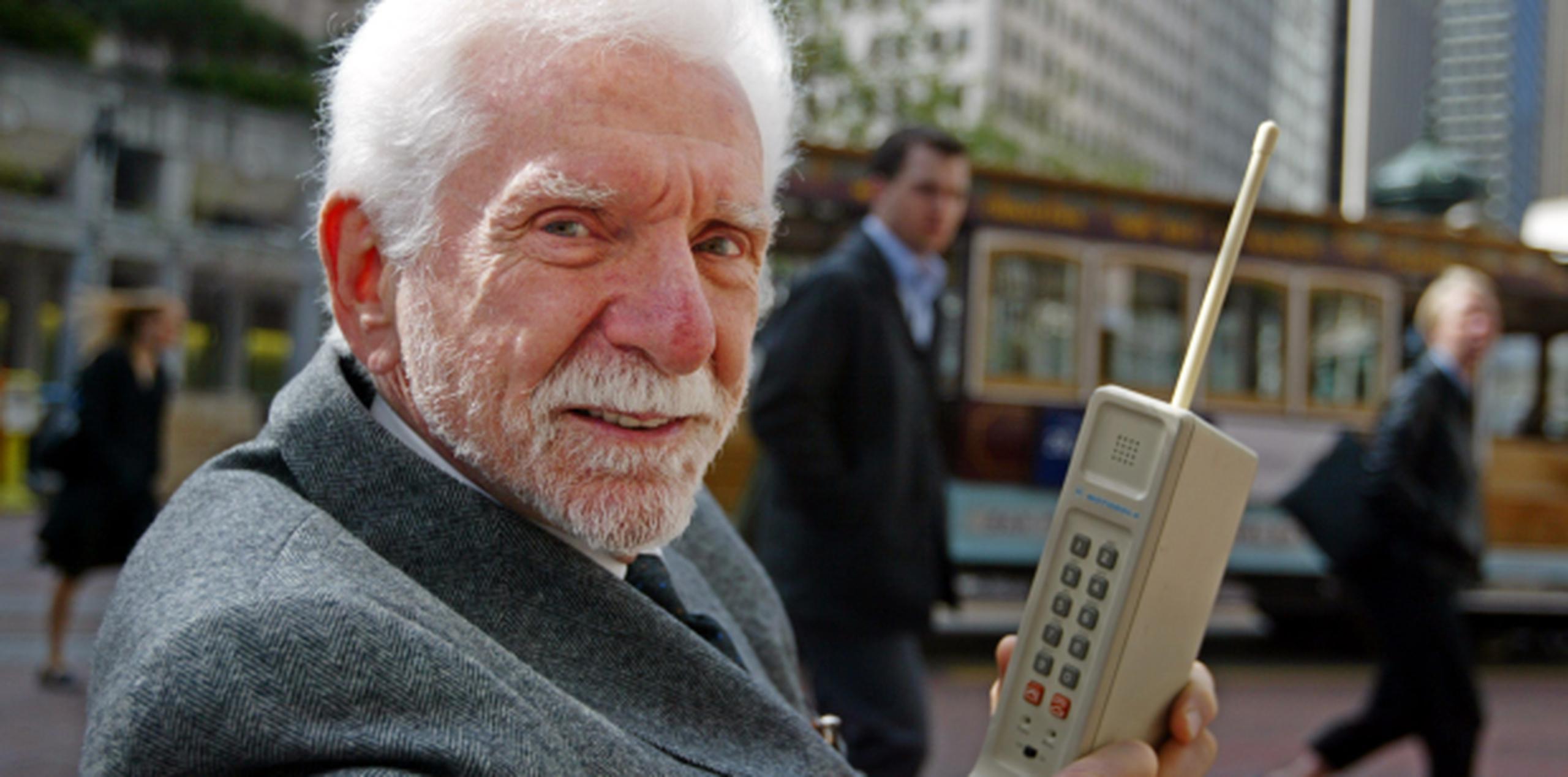Martin Cooper sostienen un prototipo del primer teléfono celular. (Archivo)