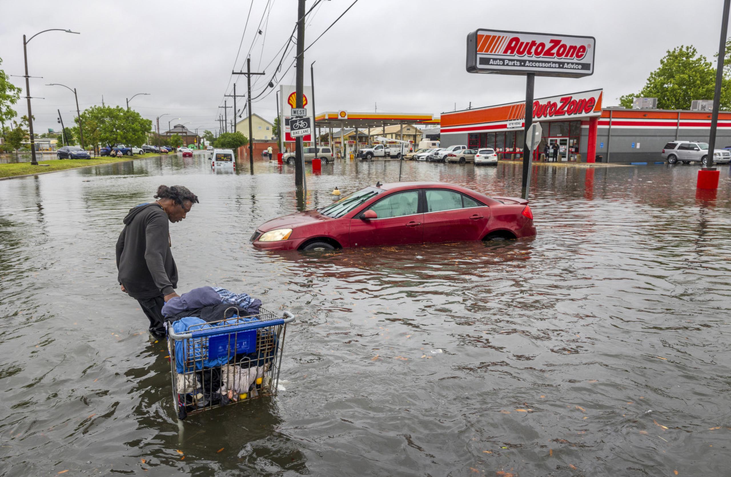 Una persona carga sus pertenencias en medio de una inundación en Broad Street el 10 de abril de 2024, en Nueva Orleans.