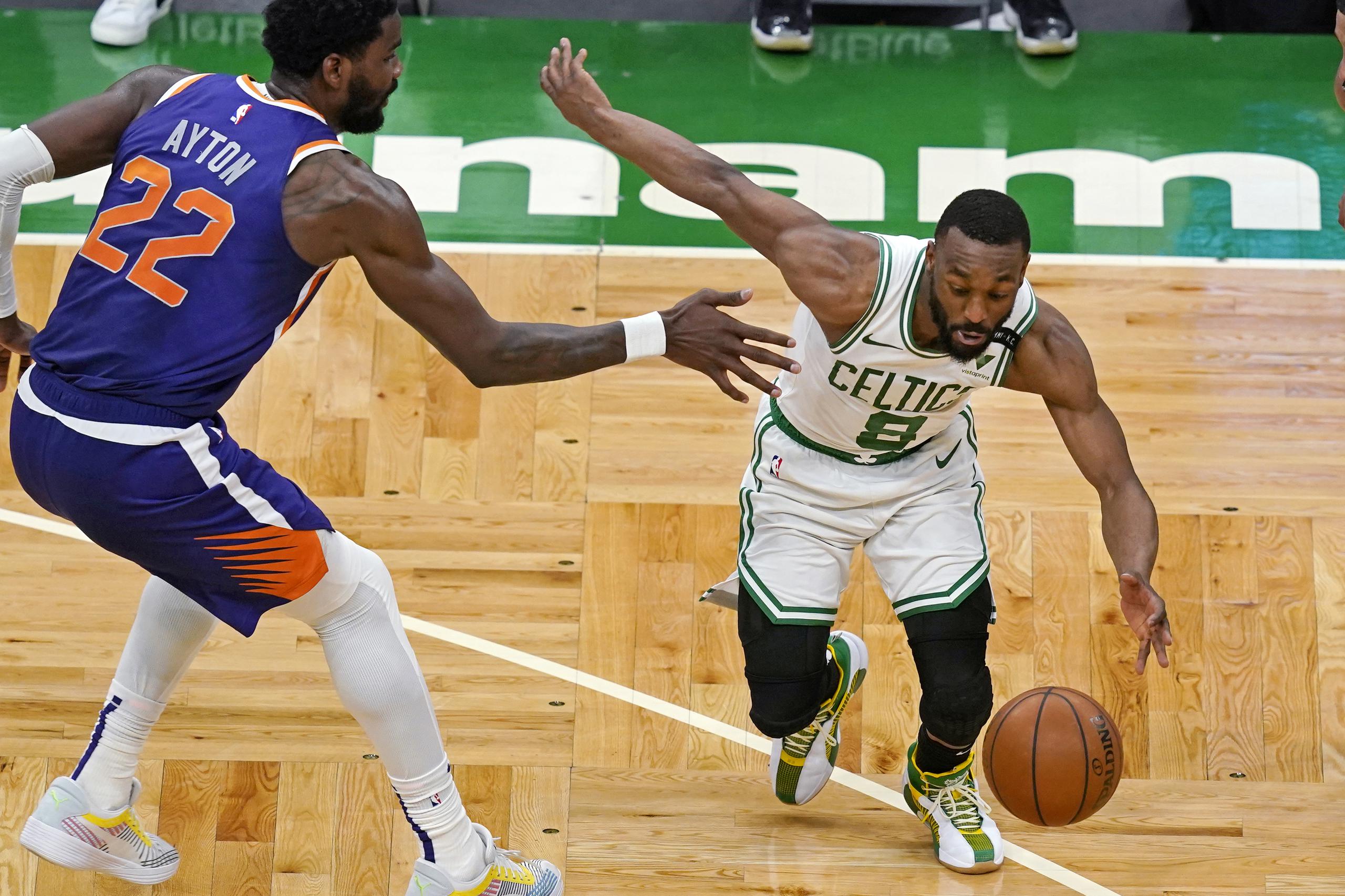 Kemba Walker, de los Celtics de Boston, maneja el balón contra la defensa del centro de los Suns, Deandre Ayton, durante la segunda mitad del encuentro del jueves.