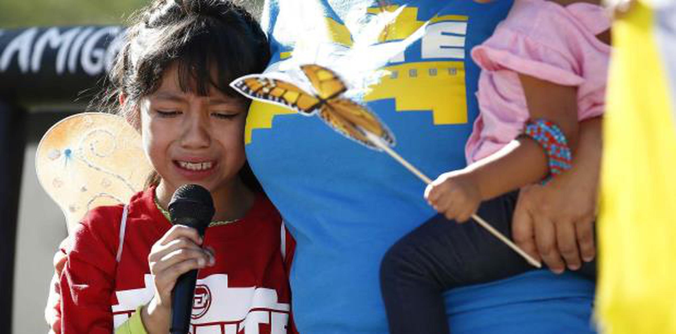 Una niña llora en medio de una protesta al recordar cómo fue separado de su padre. (AP)