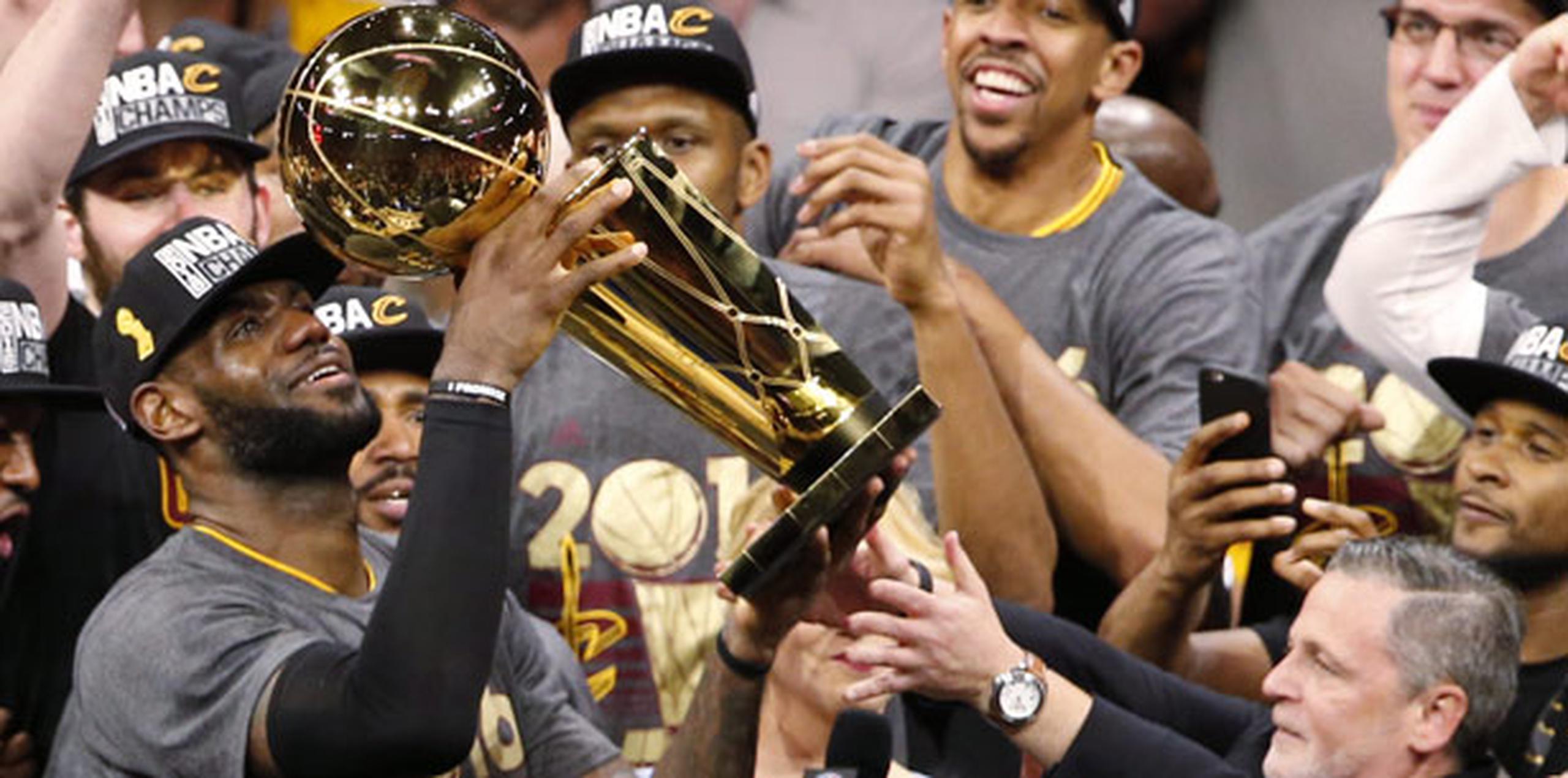 Un lloroso LeBron James levanta el trofeo de campeonato después de ayudar a los Cavaliers al derrotar a los Warriors de Golden State en un aguerrido séptimo desafío. (EFE / EPA / John G. Mabanglo)