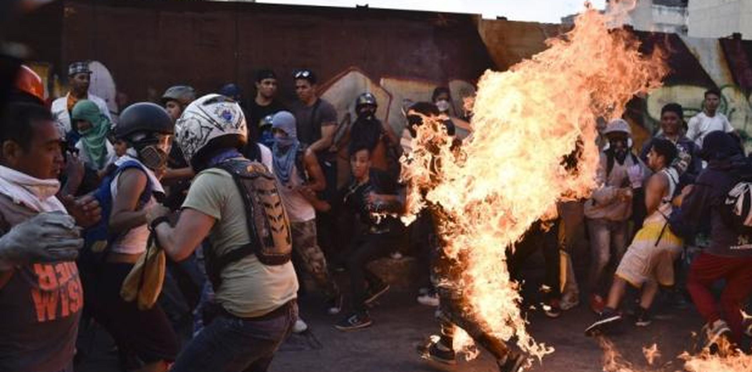 Un hombre corre envuelto en llamas luego de ser golpeado por manifestantes de la oposición de Venezuela en Caracas. (GDA)