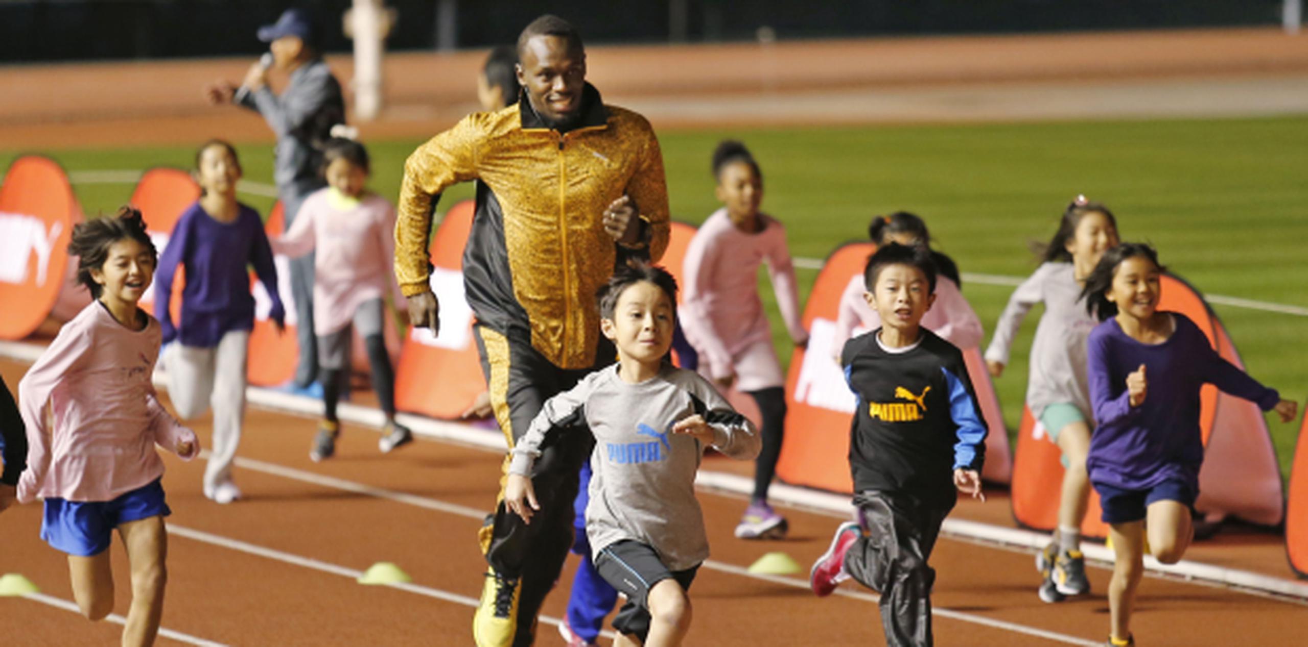 Usain Bolt comparte con niños durante una clínica deportiva en Tokio. (AP/Shuji Kajiyama)