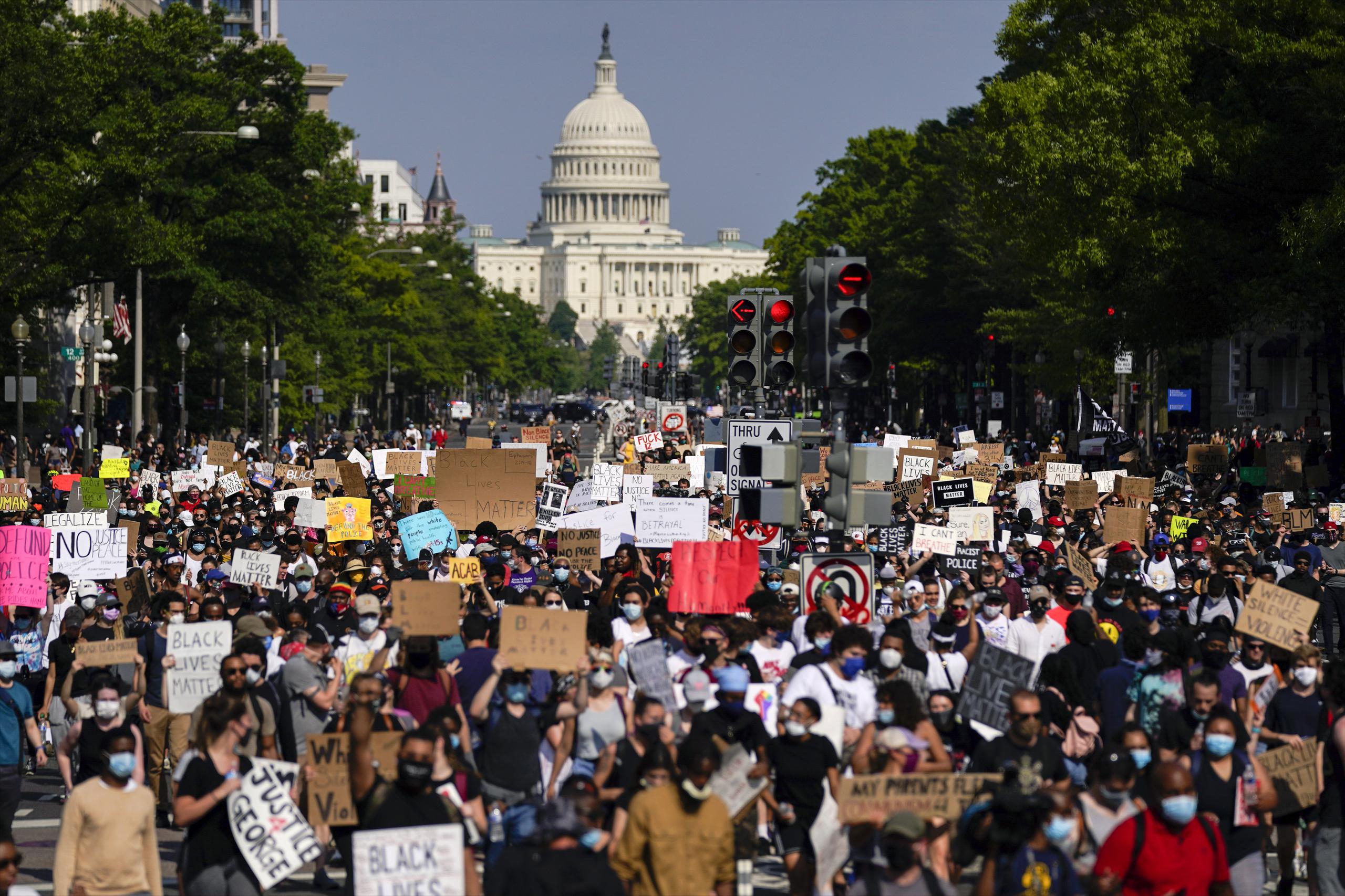 Manifestantes caminan por la avenida Pensilvania durante una protesta por la muerte de George Floyd, en Washington
