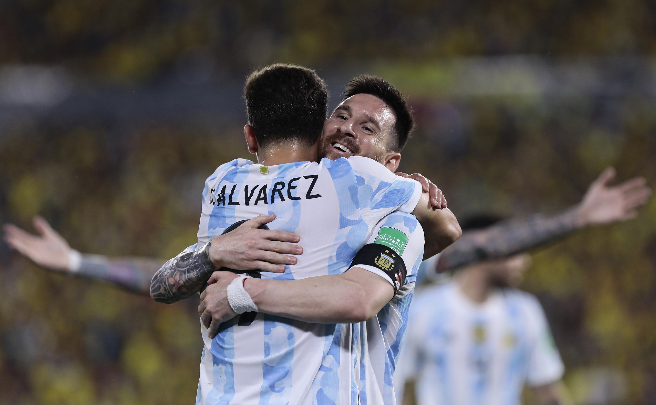 Julián Álvarez se abraza con Lionel Messi tras anotar un gol para Argentina ante Ecuador en las eliminatorias del Mundial, el martes 29 de marzo de 2022, en Guayaquil. (Franklin Jacome/Pool vía AP)