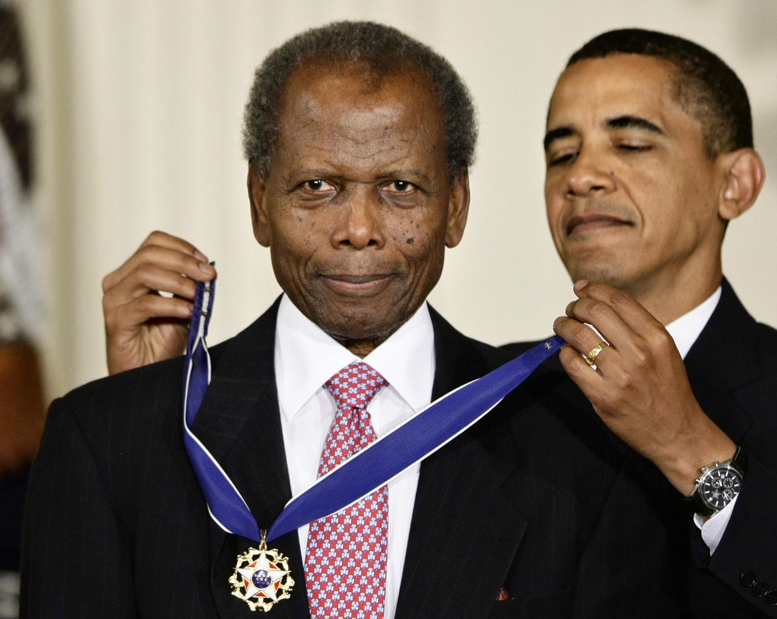 Barack Obama le coloca la Medalla presidencial de la libertad a Sidney Poitier en 2009. (AP Photo/J. Scott Applewhite, File)