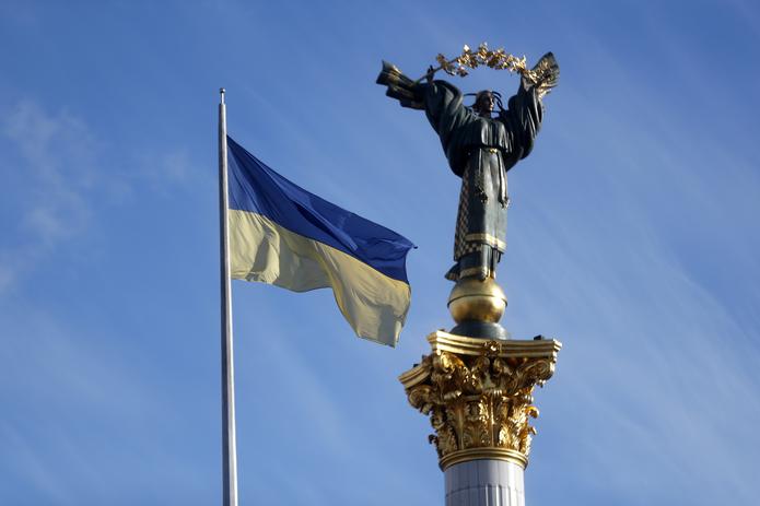 La bandera ucraniana junto al monumento a la independencia en Kiev.