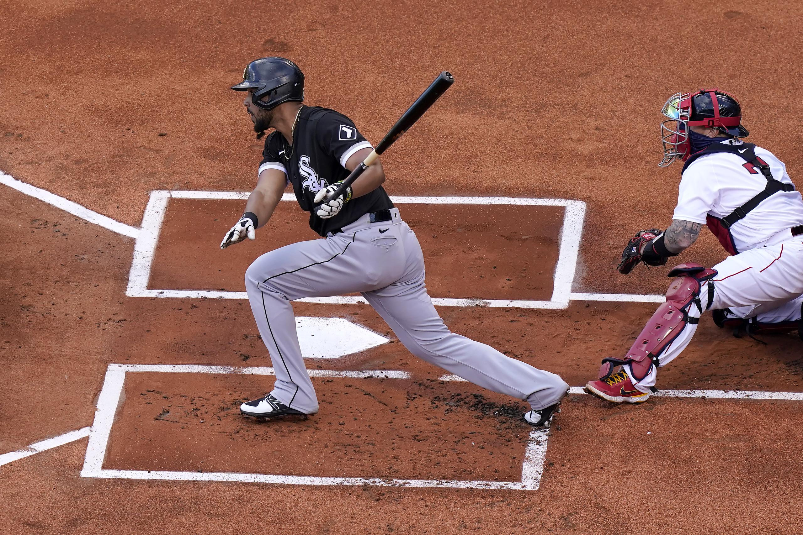 El cubano José Abreu, de los White Sox, dispara un batazo mientras observa el boricua de los Red Sox, Christian Vázquez.