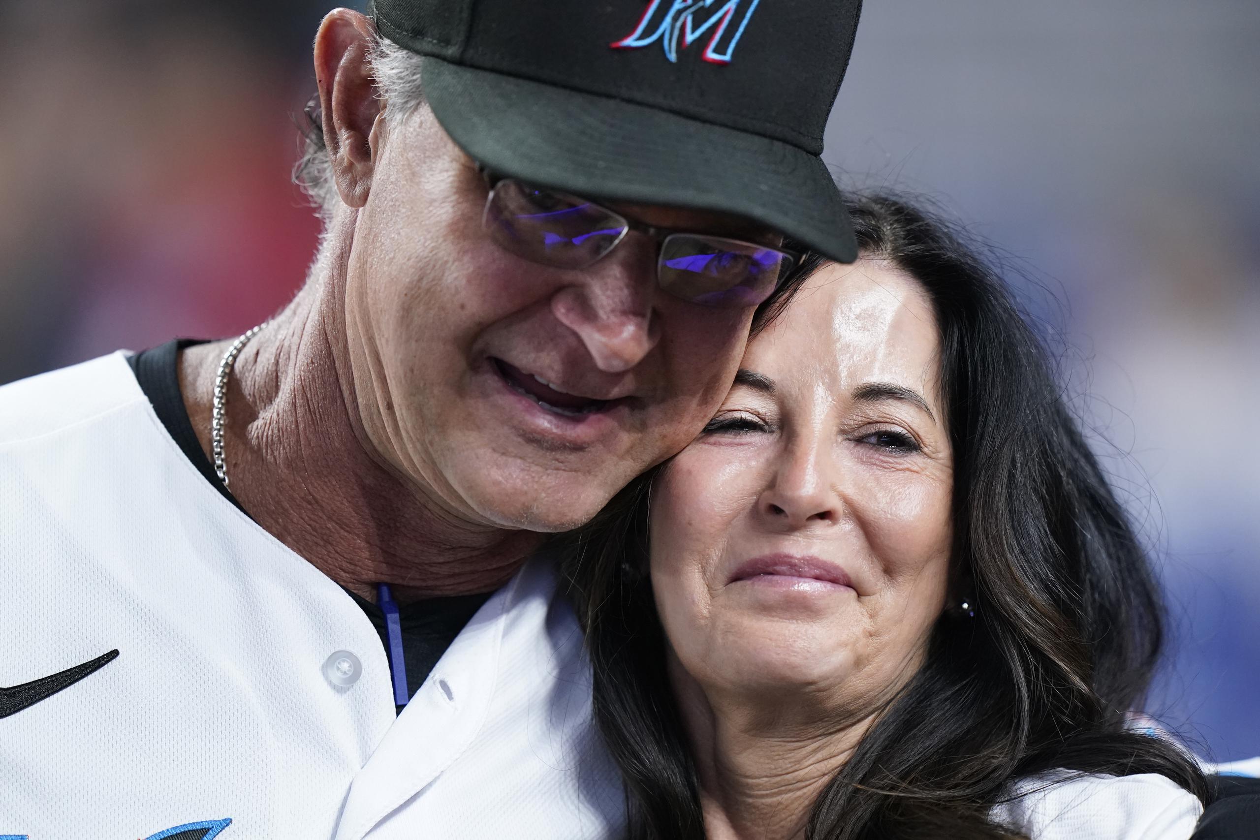 Don Mattingly, manager de los Marlins de Miami, abraza a su esposa Lori Mattingly, durante el reconocimiento dentro del campo en la quinta entrada del juego del miércoles ante los Braves de Atlanta.