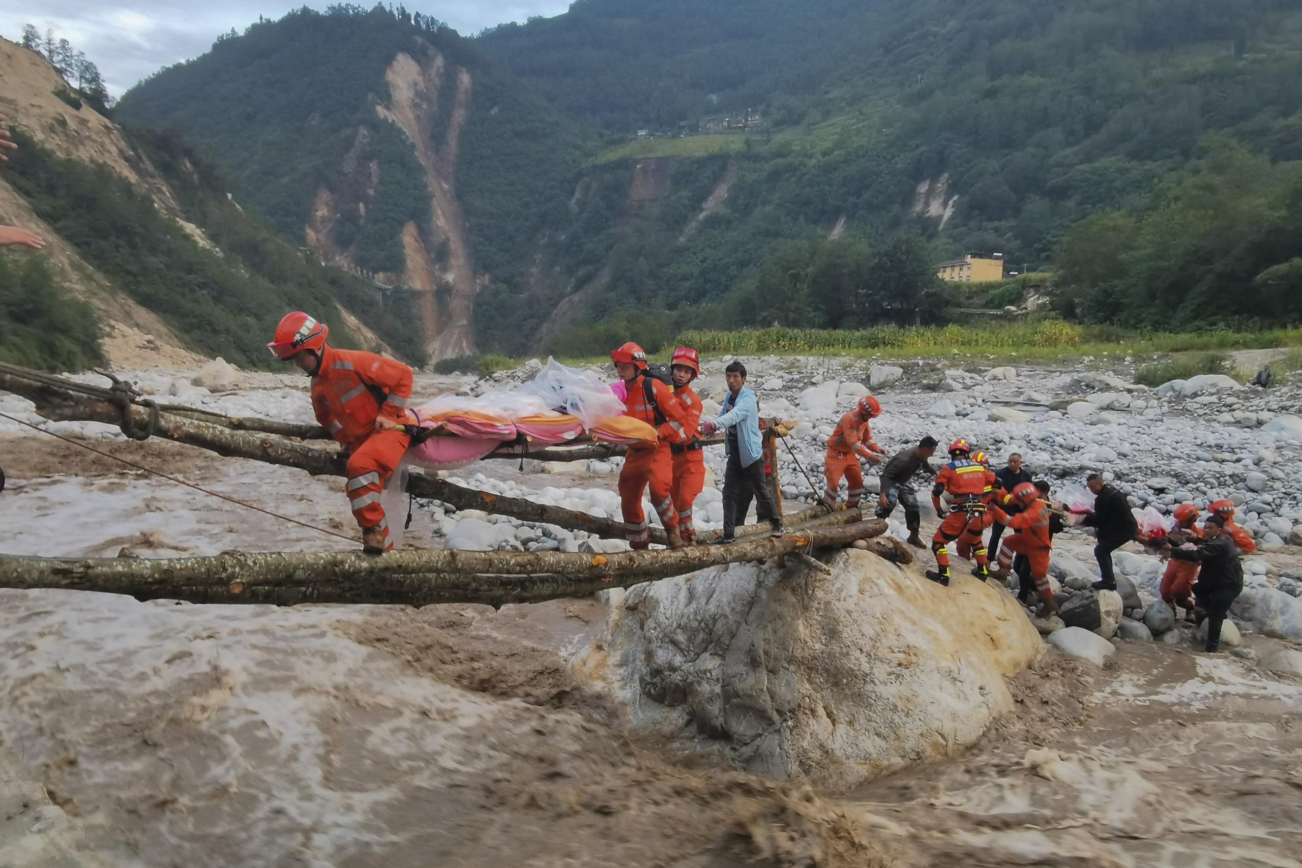 En esta imagen, distribuida por la agencia noticiosa Xinhua, rescatistas trasladan a sobrevivientes al otro lado de un río luego de un sismo en la localidad de Moxi, en el condado de Luding de la provincia de Sichuan, en el suroeste de China, el 5 de septiembre de 2022. (Cheng Xueli/Xinhua vía AP)