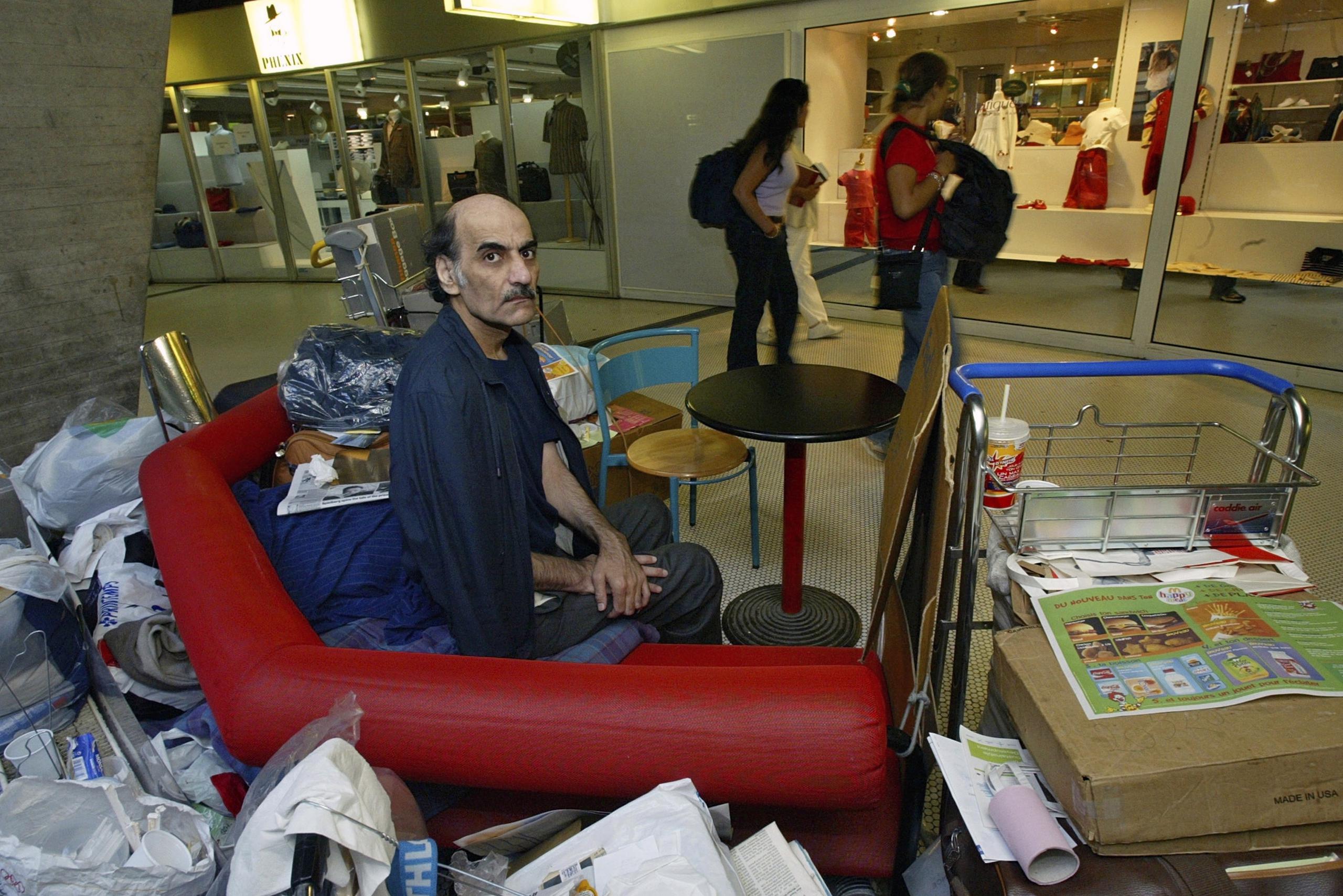 Merhan Karimi Nasseri sentado entre sus pertenencias en la Terminal 1 del aeropuerto Charles De Gaulle, en París el 11 de agosto de 2004.