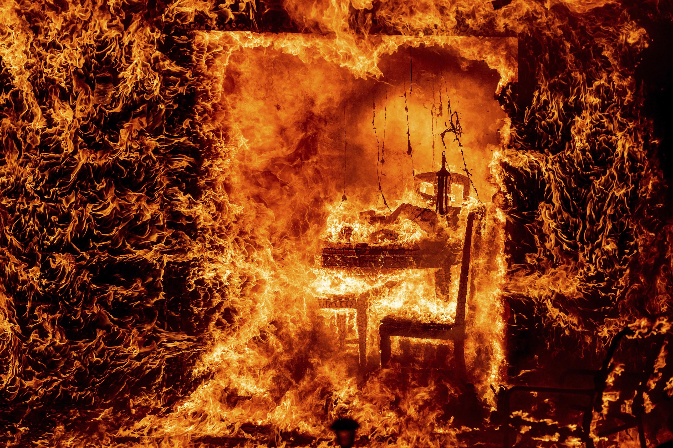 Las llamas consumen una silla dentro de una casa en llamas mientras el Oak Fire arde en el condado de Mariposa, California, el sábado 23 de julio. (Foto AP/Noah Berger)
