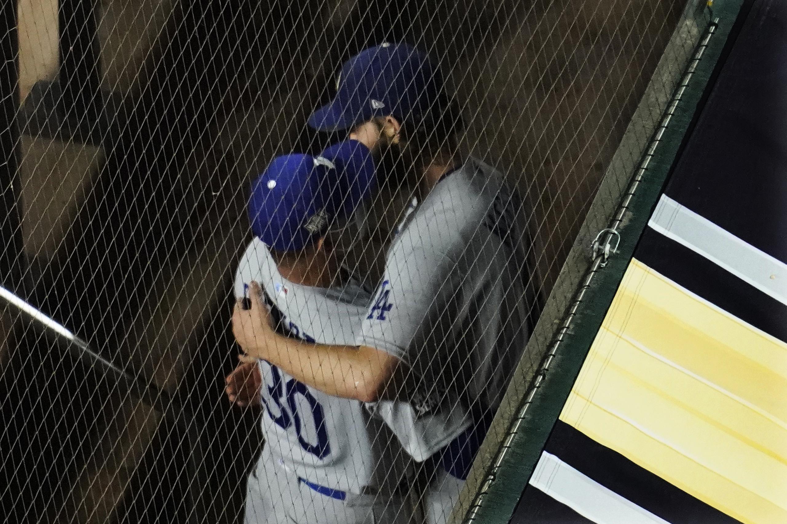 El dirigente de los Dodgers, Dave Roberts, abraza al lanzador Clayton Kershaw luego de removerlo en la sexta del partido del domingo luego de retirar a dos bateadores. Según dijeron ambos, la decisión fue una planificada y discutida por ambos.