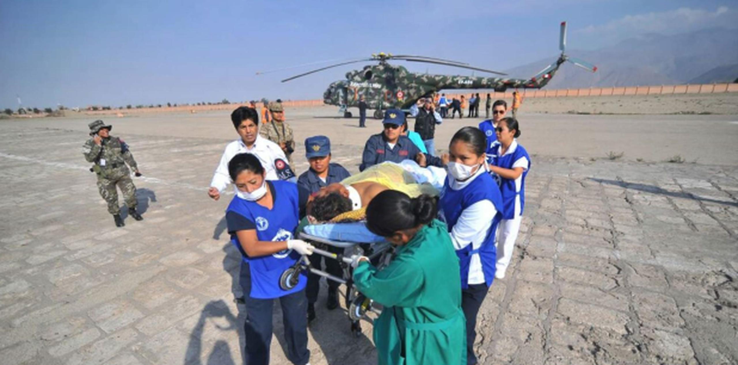 Trabajadores de la salud transportan a un hombre que sufrió herida en el accidente de autobús en Arequipa, Perú. (AP / Diego Ramos)