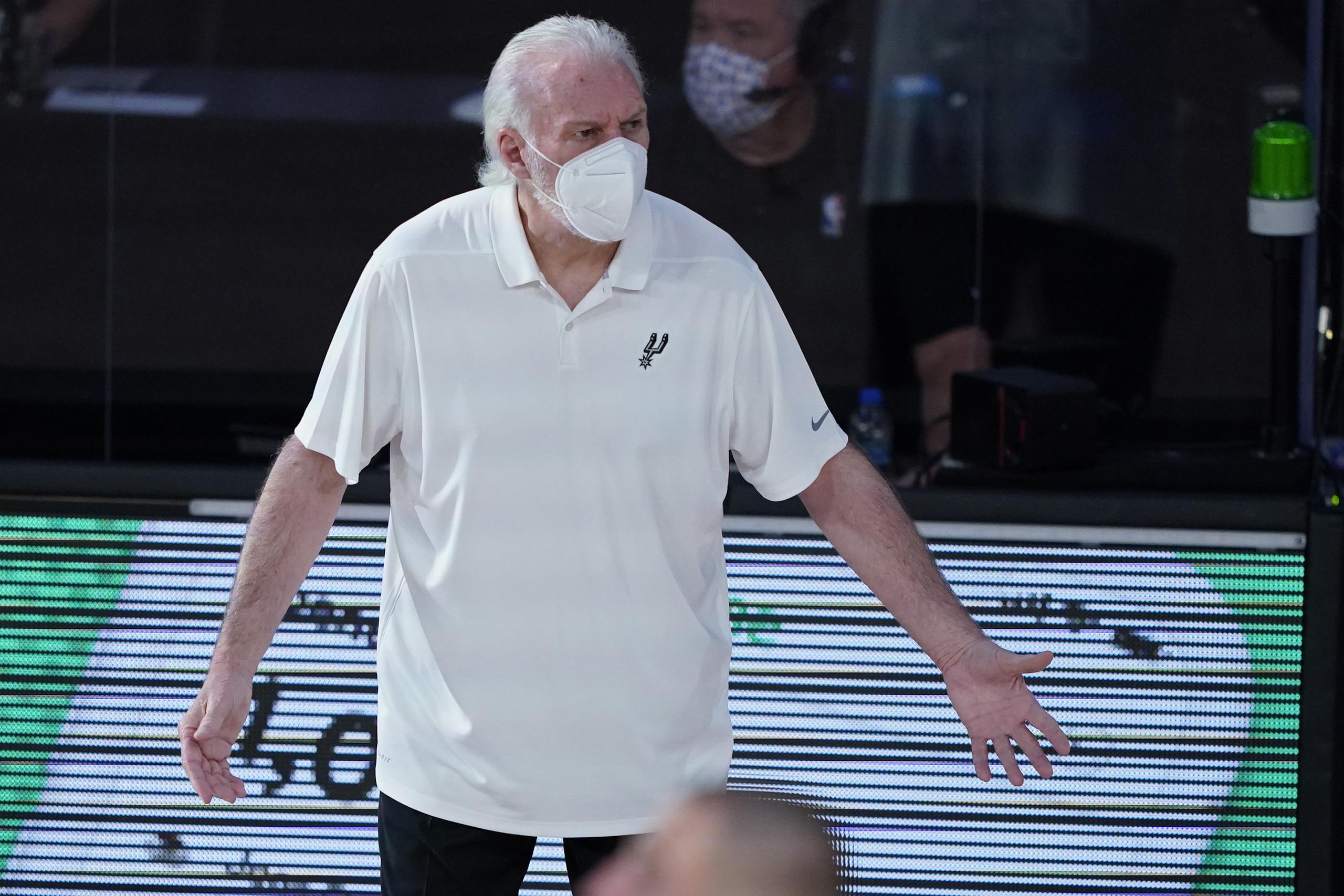 En esta foto del 2 de agosto del 2020, el coach de los Spurs de San Antonio Gregg Popovich se ve dirigiendo un juego ante los Grizzlies de Memphis en la 'burbuja' de la NBA en Orlando portando una máscara. Para la nueva temporada que iniciará el 22 de diciembre, los entrenadores tendrán como requisito el llevar tapabocas en los partidos.