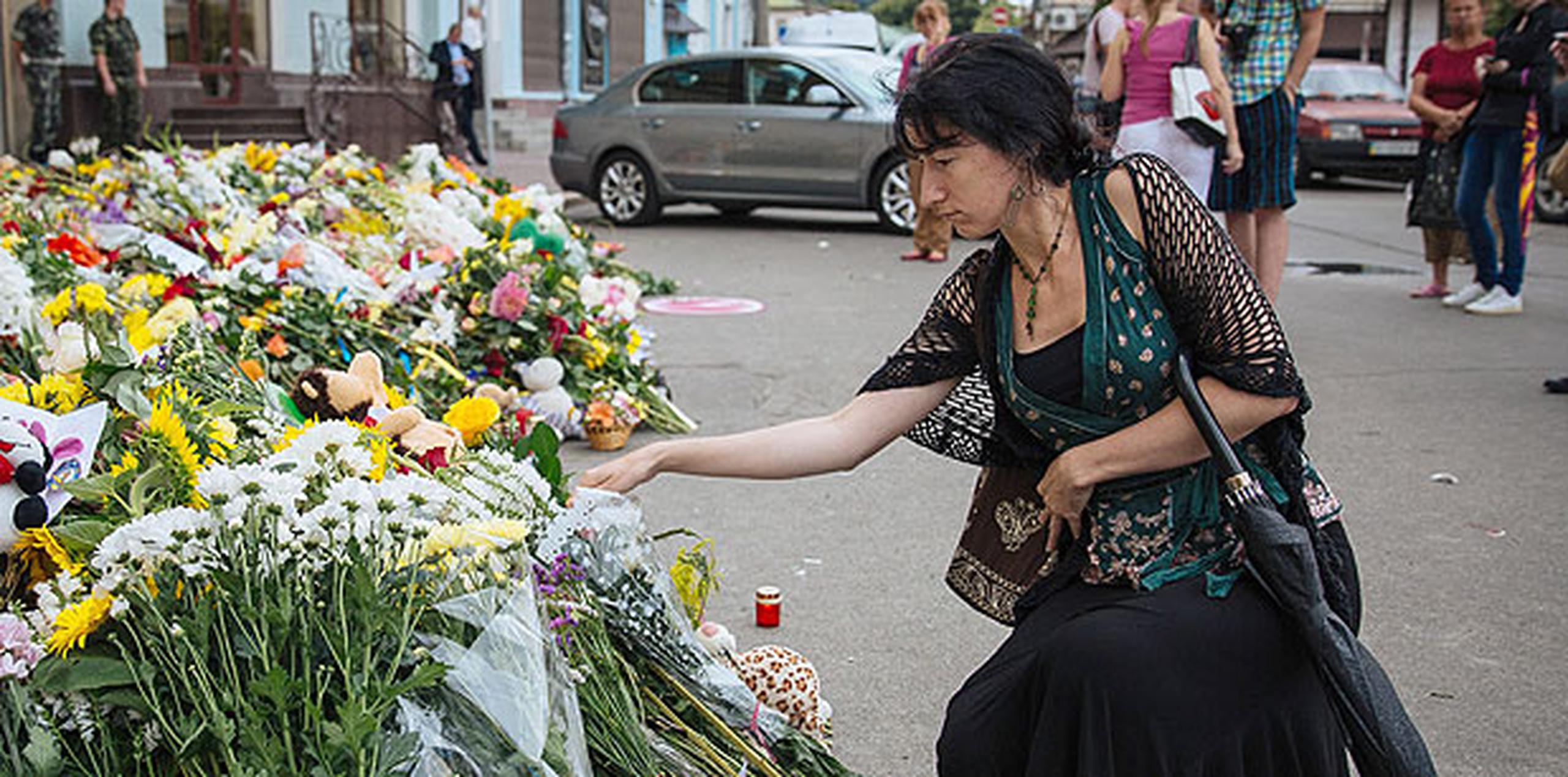 Viajeros que pasaban por el aeropuerto de Schiphol dejaban flores en recuerdo de las víctimas. (AP)