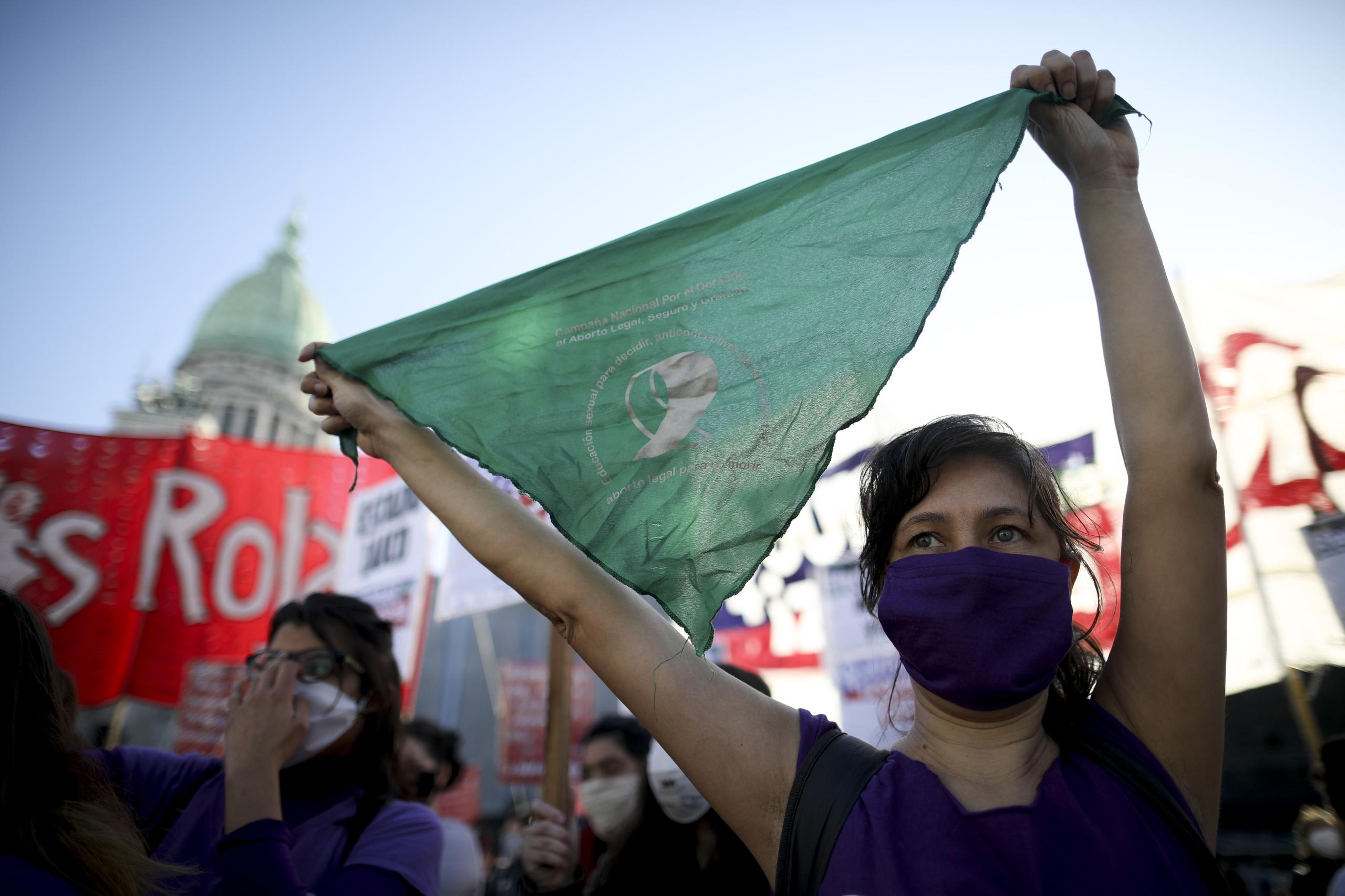 Una activista en favor del aborto levanta un icónico pañuelo verde durante una protesta que apoya su despenalización afuera del Congreso en medio de una cuarentena para bajar la curva del contagios del nuevo coronavirus en Buenos Aires.