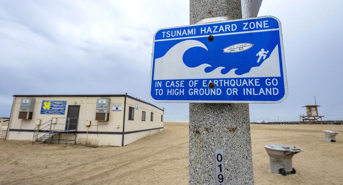 Una señal de peligro de tsunami en un poste de luz cerca del muelle de Balboa en Newport Beach, California, el sábado 15 de enero de 2022 por la mañana. Se emitió un aviso de tsunami para Hawái y la costa oeste de EE. nación del Pacífico de Tonga el sábado. (Mark Rightmire/El Registro del Condado de Orange vía AP)