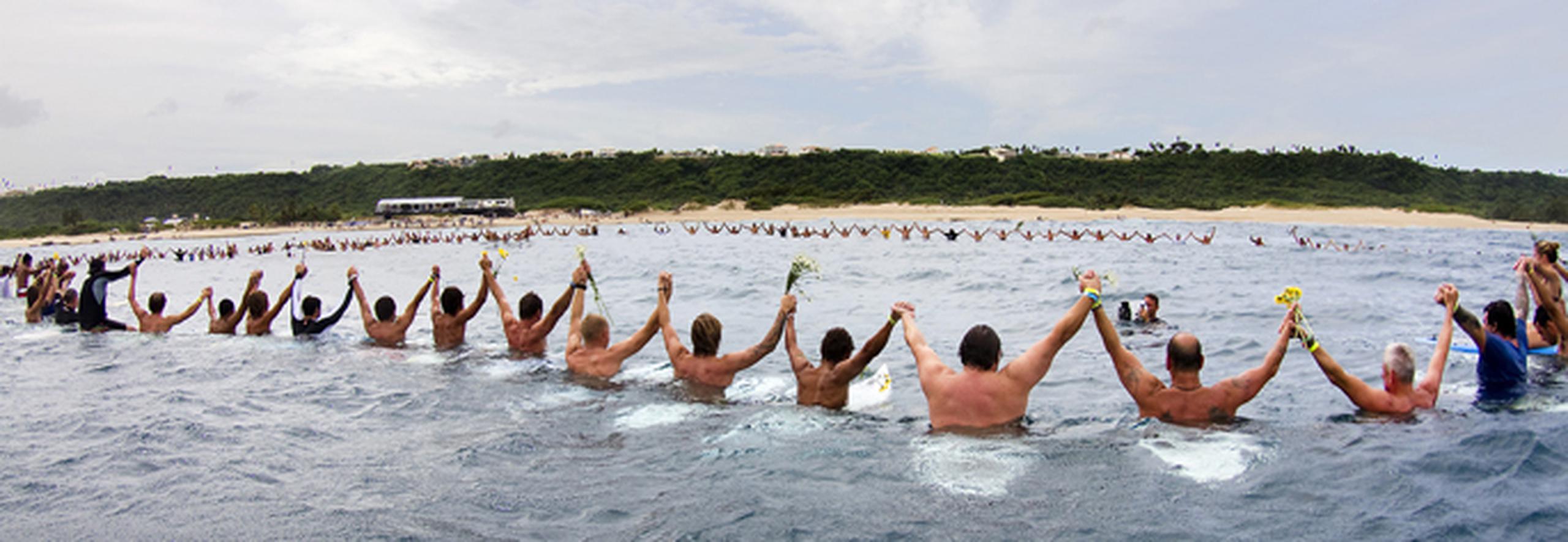 Decenas de surfers levantaron sus brazos durante un acto de recordación efectuado hoy en la playa Middles, en Isabela, en memoria de Andy Irons. Muchos de ellos cargaron ramos de flores que fueron lanzadas al mar en homenaje al atleta.   (Suministrada ASP/ Cestari)