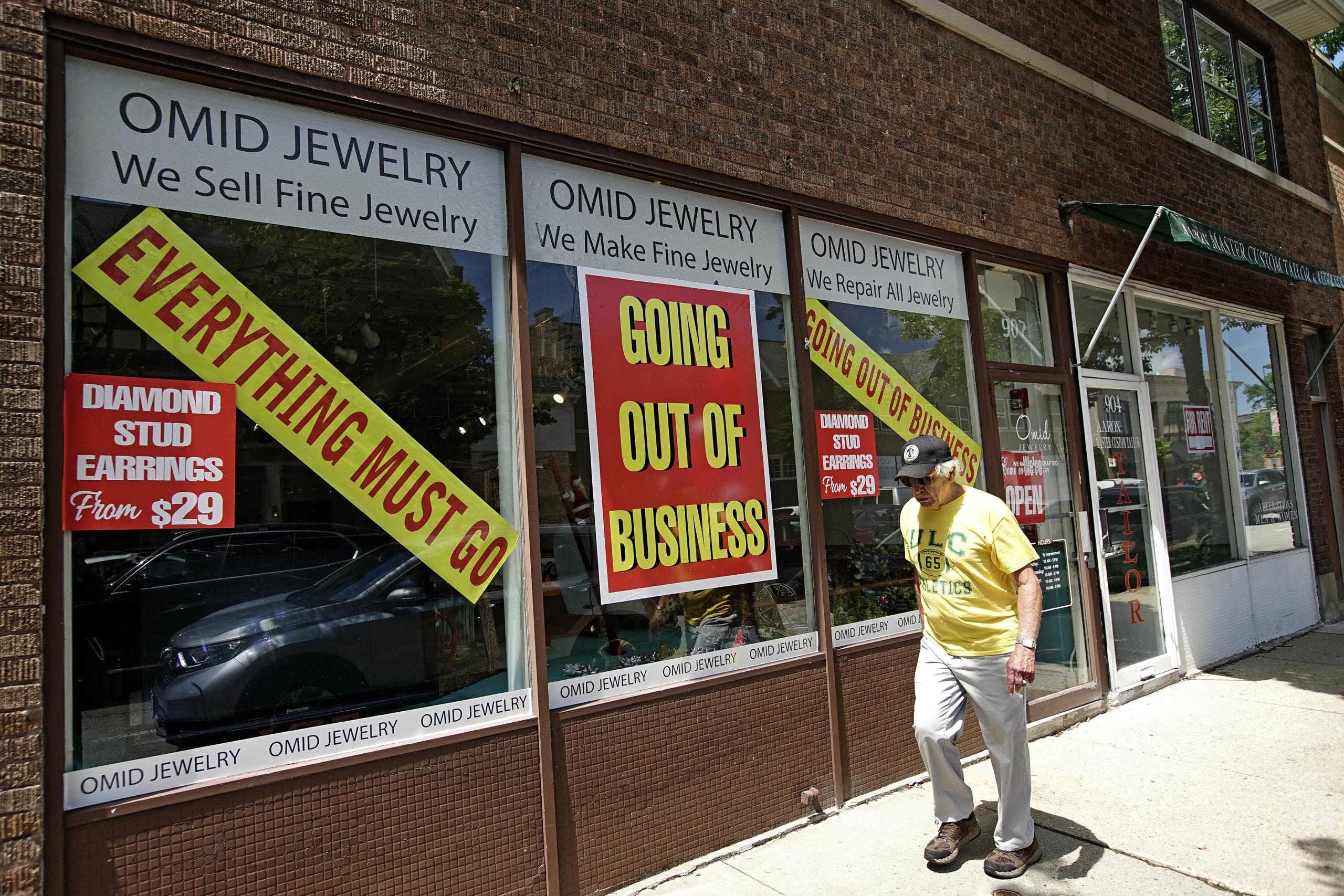 Un hombre pasa por al frente de un comercio que cerró tras la pandemia en Illinois, Estados Unidos.