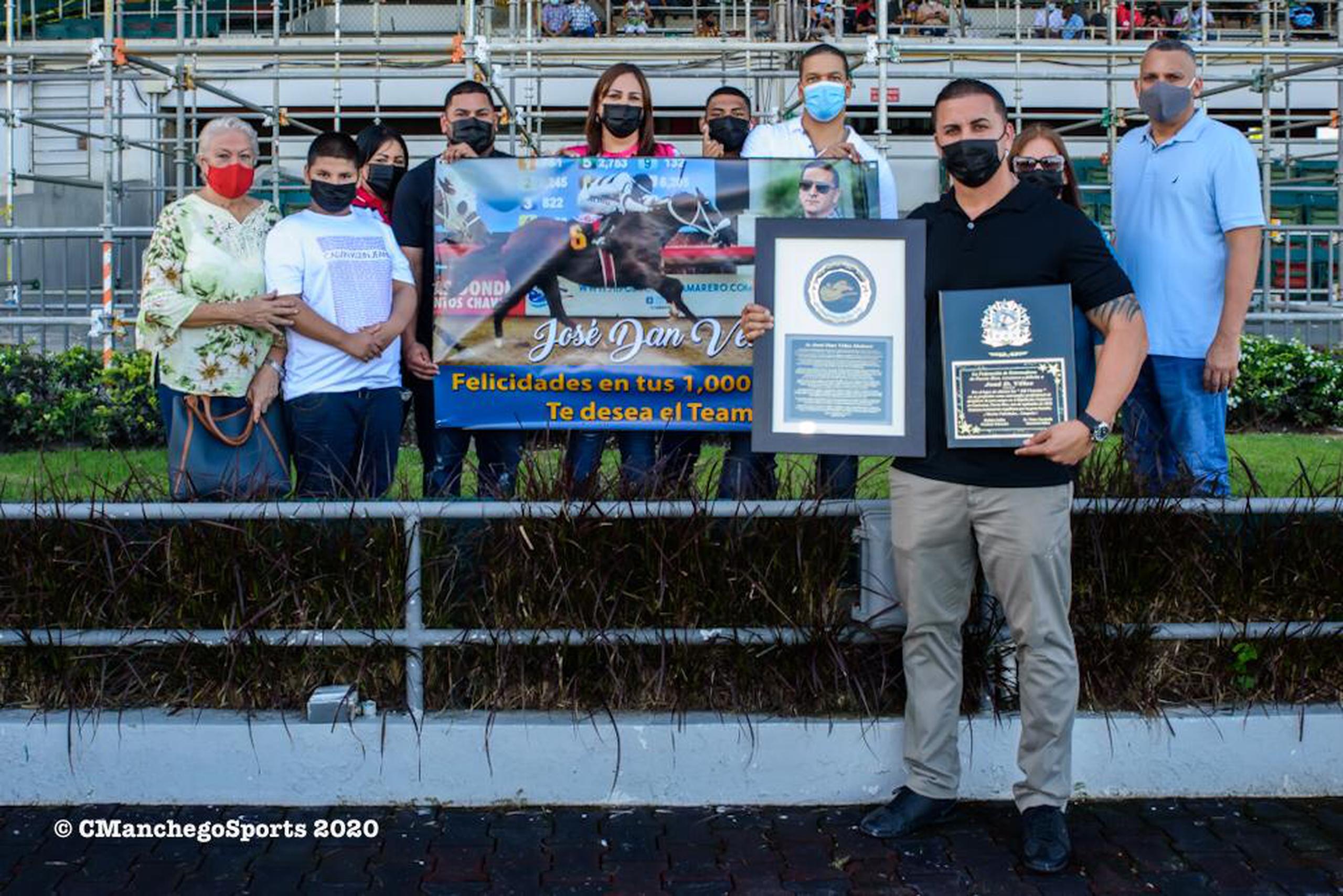 José Dan Vélez posa junto a familiares, equipo de trabajo, placas y recordatorios alusivos a su victoria 1,000 como entrenador en el hipódromo Camarero.