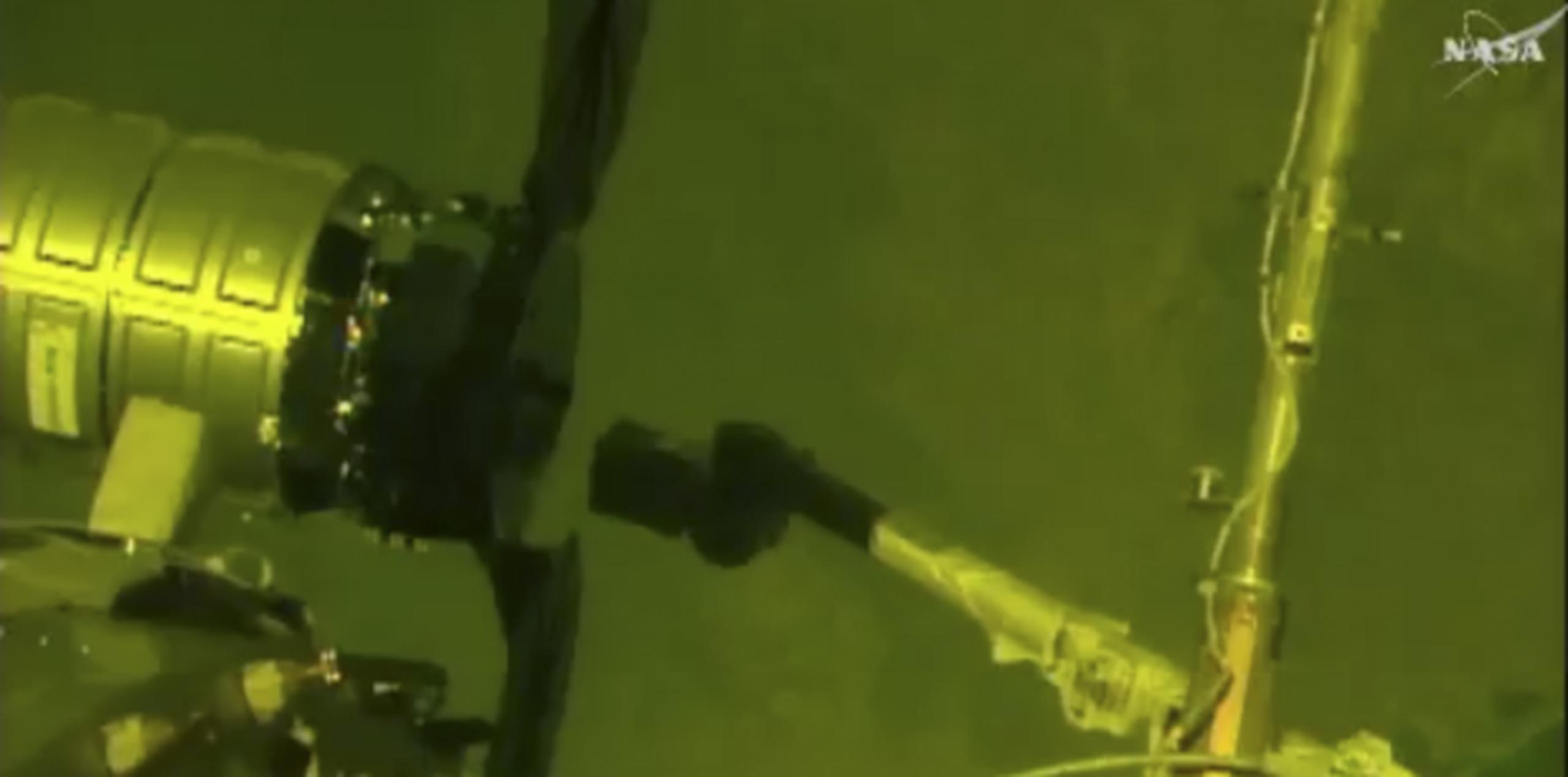 Momento en el que el brazo mecánico de la nave de suministros S.S. John Glenn alcanza la Espación Espacial Internacional. (NASA via AP)
