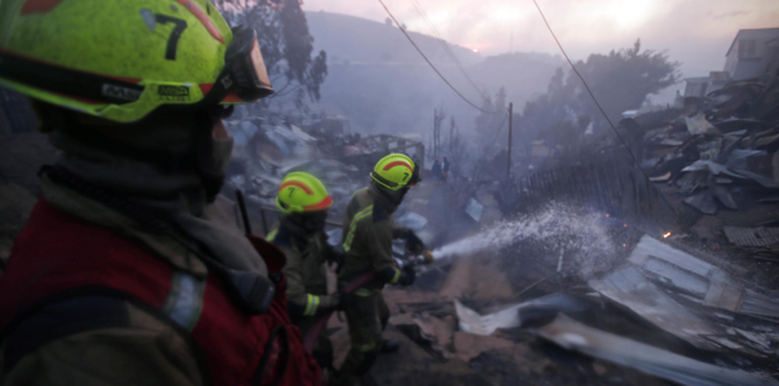 Bomberos tratan de controlar las llamas en Valparaíso, Chile. (Agencia EFE)