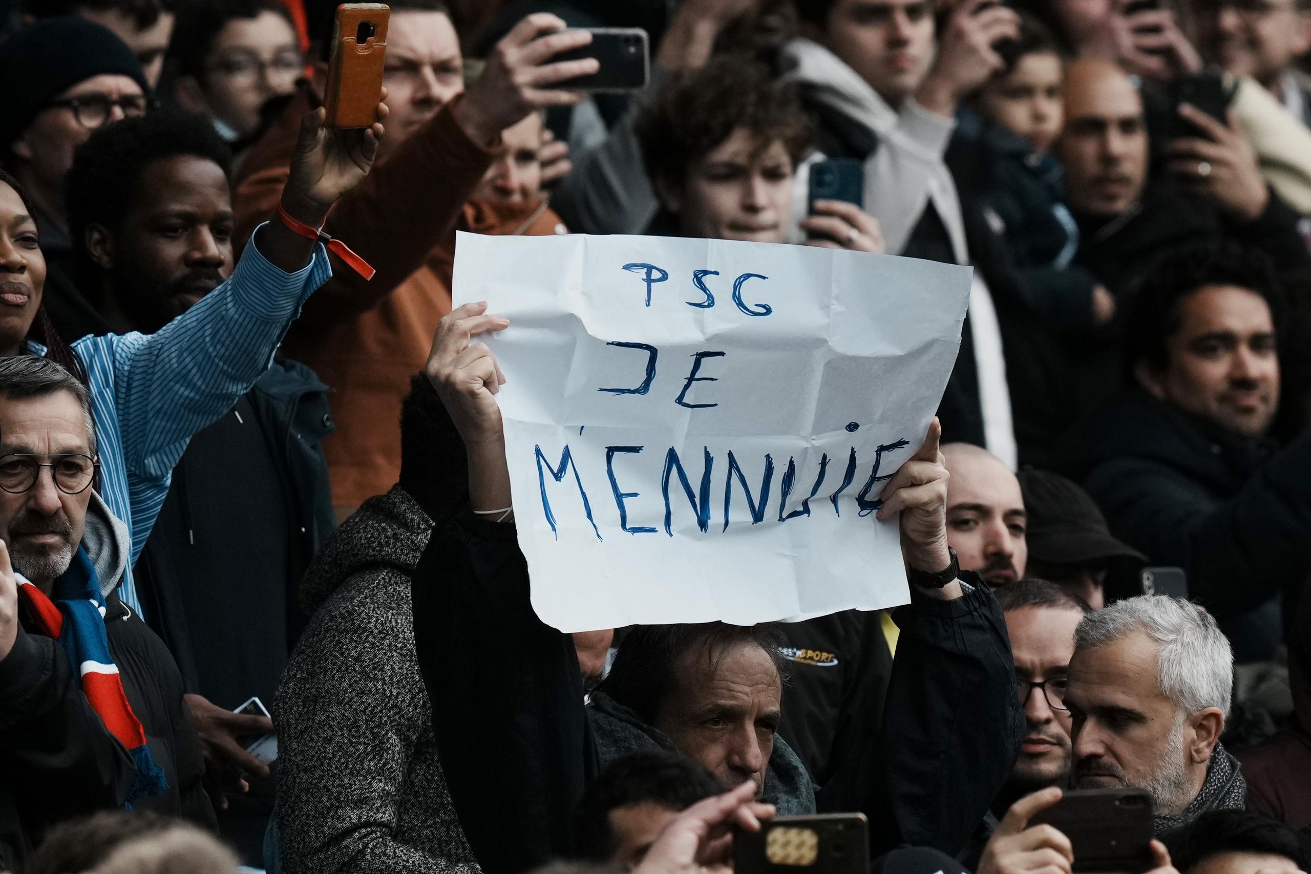 Un aficionado con un cartel con la frase 'PSG Je mennuie' ('PSG Estoy Aburrido') durante el partido de la liga francesa entre el PSG y el Burdeos, el domingo 13 de marzo de 2022.