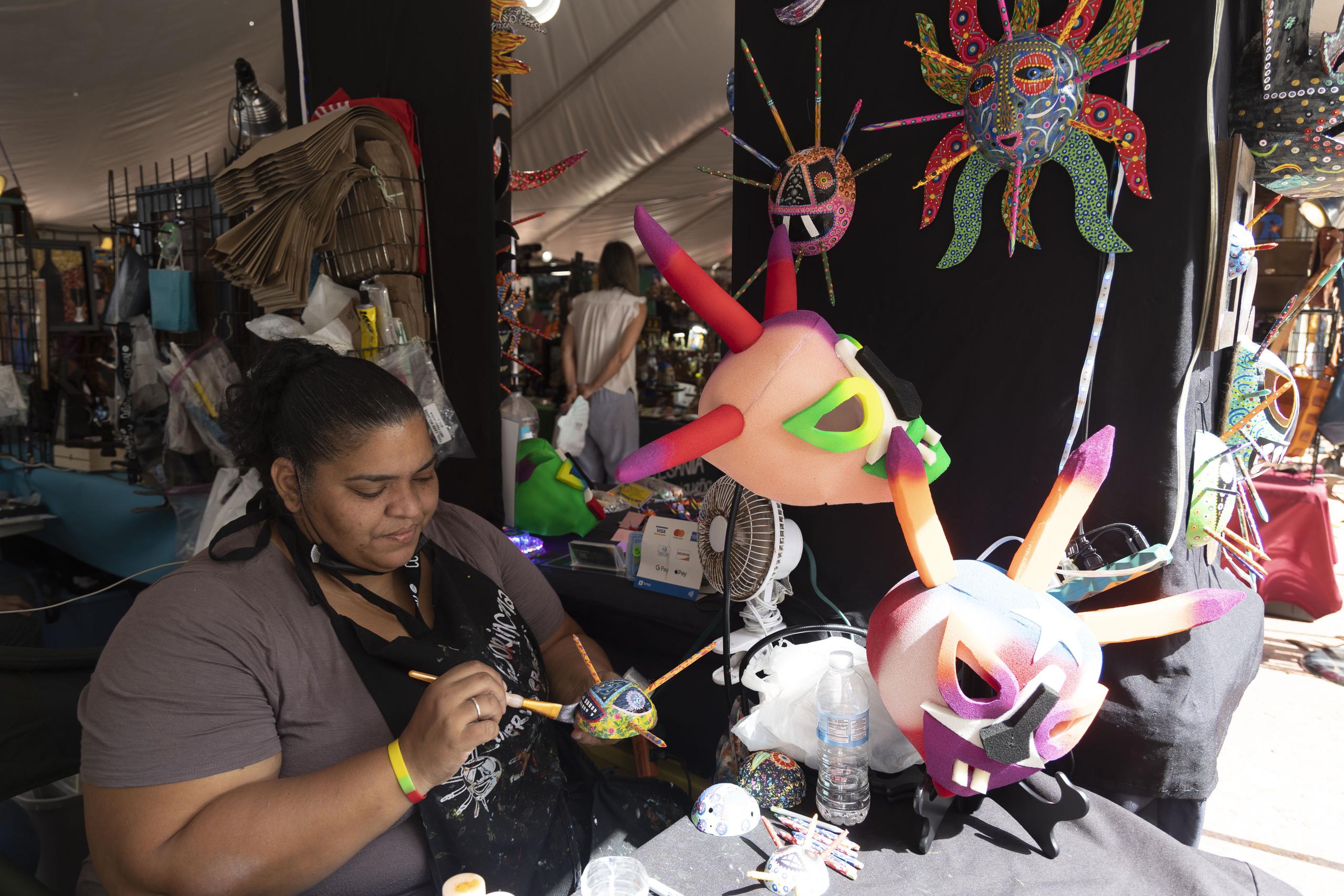 Minerva Hernández, dando los detalles finales a una máscara de vejigante, es una de cientos de artesanos que exhiben este año en las Fiestas de la Calle San Sebastián.