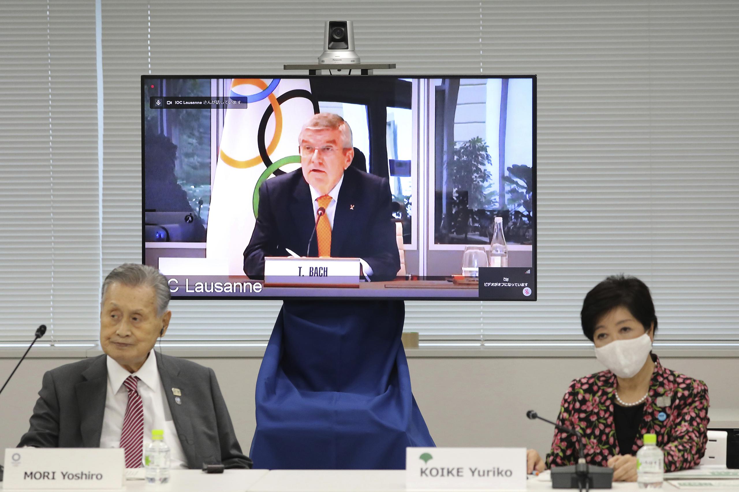En esta imagen de archivo del 24 de septiembre de 2020, el presidente del COI, Thomas Bach, aparece en la pantalla para intervenir a distancia con el presidente del Comité Organizador Yoshiro Mori, a la izquierda, y la gobernadora de Tokio, Yuriko Koike, a la derecha durante una reunión virtual sobre los aplazados Juegos Olímpicos de Tokio, en Tokio. 