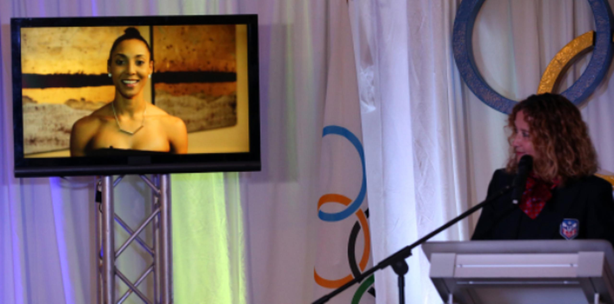 La presidenta del Comité Olímpico de Puerto Rico (COPUR) Sara Rosario (der.) observa el vídeo mensaje enviado por Aury Cruz durante la presentación de la delegación boricua celebrada ayer en la Casa Olímpica. (jose.candelaria@gfrmedia.com)