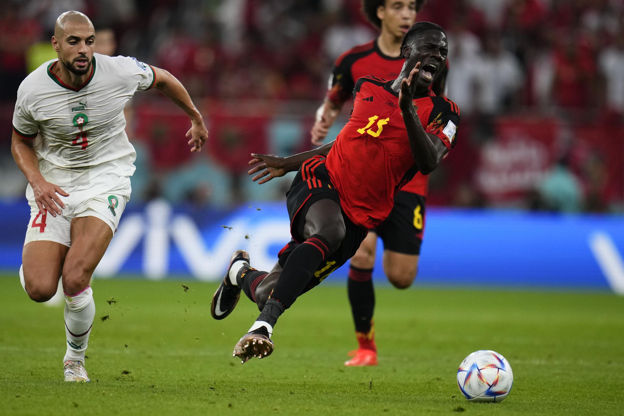 El belga Amadou Onana cae ante el marroquí Sofyan Amrabat durante un partido del Grupo E del Mundial que enfrentó a ambos equipos, en el estadio Al Thumama, en Doha, Qatar, el 27 de noviembre de 2022. (AP Foto/Manu Fernández)