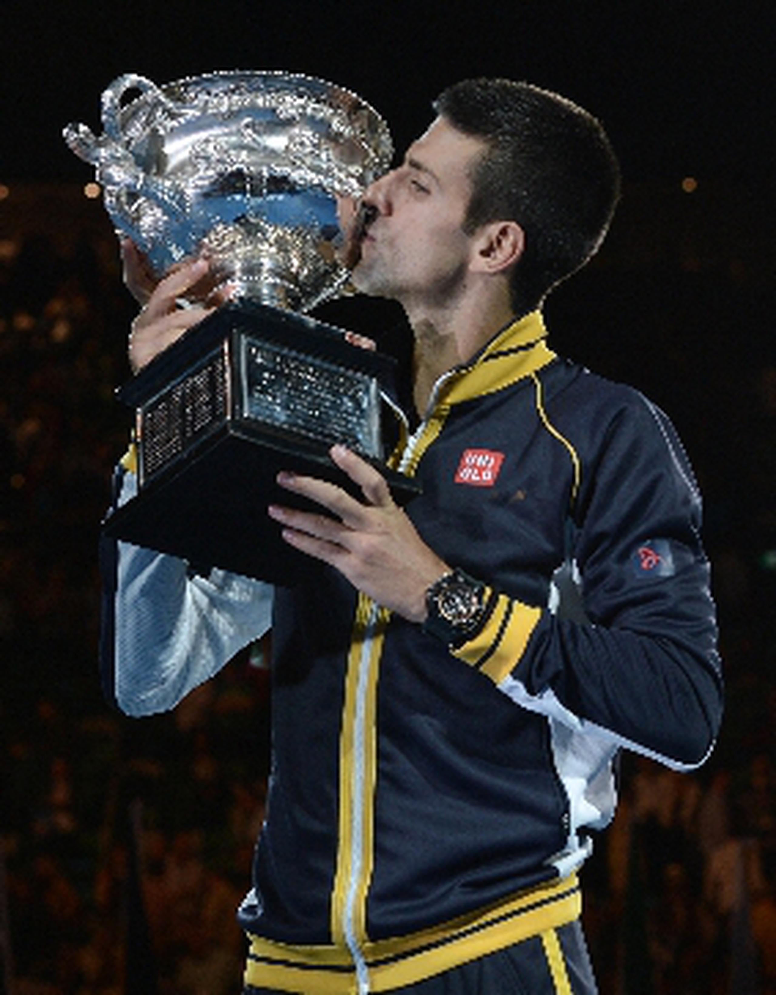   Novak Djokovic besa el trofeo de campeonato durante la ceremonia de premiación en Melbourne. &nbsp;<font color="yellow">(AFP)</font>