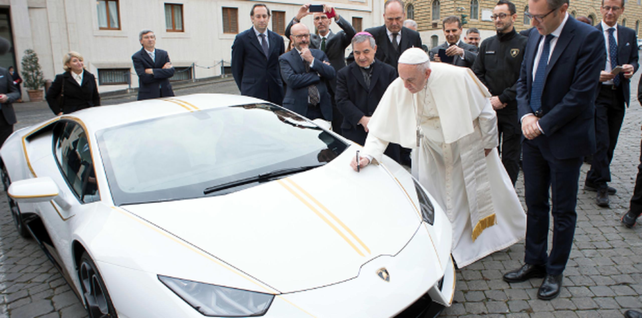 El papa Francisco firma el Lamborghini Huracan que le regalaron y que subastará para su labor benéfica. (Servizio Fotografico-L'Osservatore Romano via AP)