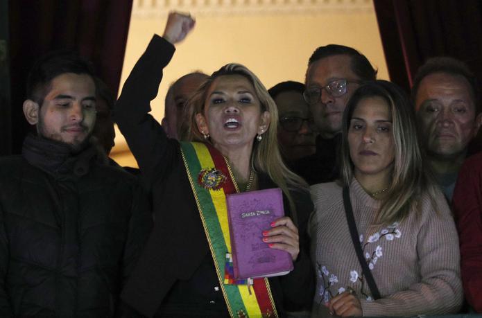 Jeanine Áñez, en el centro y con la faja presidencial, se dirige a la multitud el martes 12 de noviembre de 2019 desde el balcón del palacio presidencial después de declararse mandataria interina de Bolivia, en La Paz.
